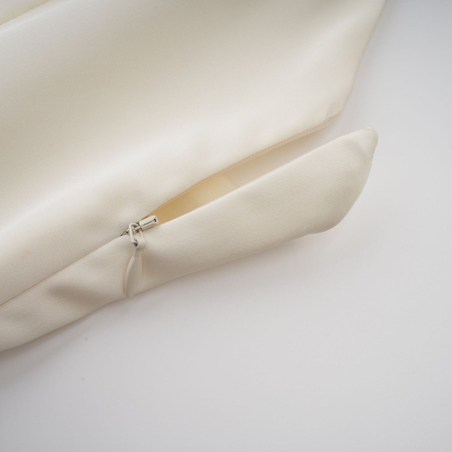 A white satin mini dress with ruffled details and a shawl panel featuring a short hemline and elegant design