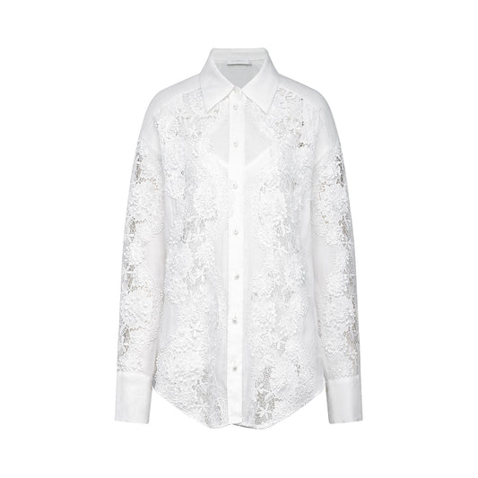 A white shirt with delicate lace embroidery and strategic cut out details featuring long sleeves and a collar