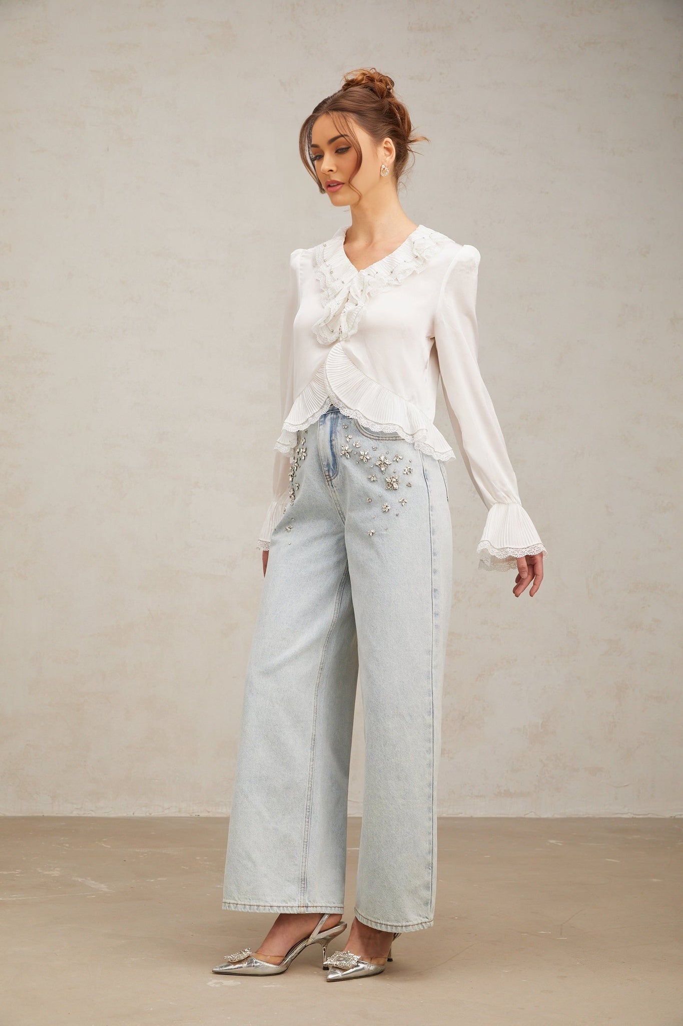 A white shirt with lace trim and ruffled details named Aimee