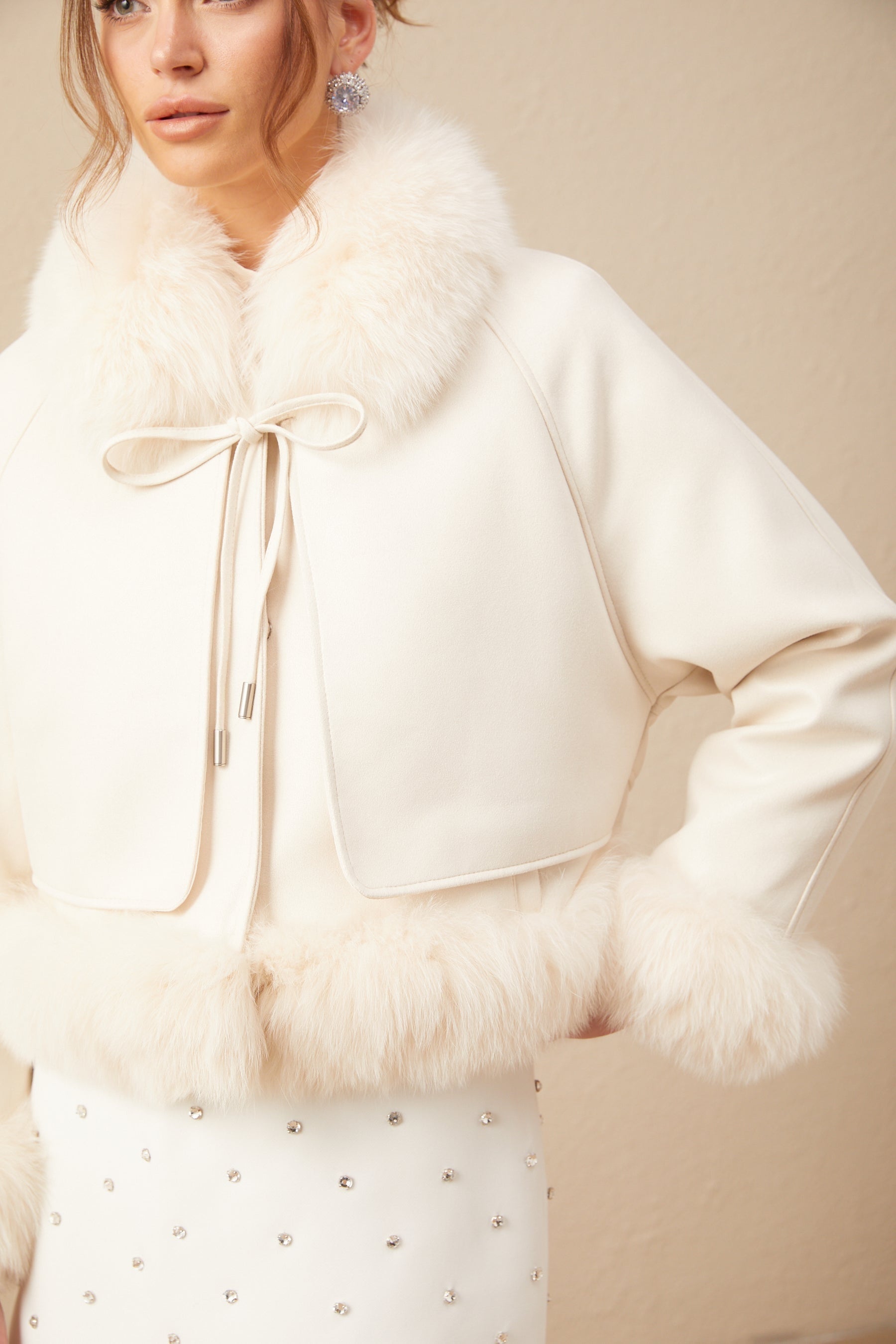 A white short coat made of suede with fur padding and a cozy appearance ideal for winter wear