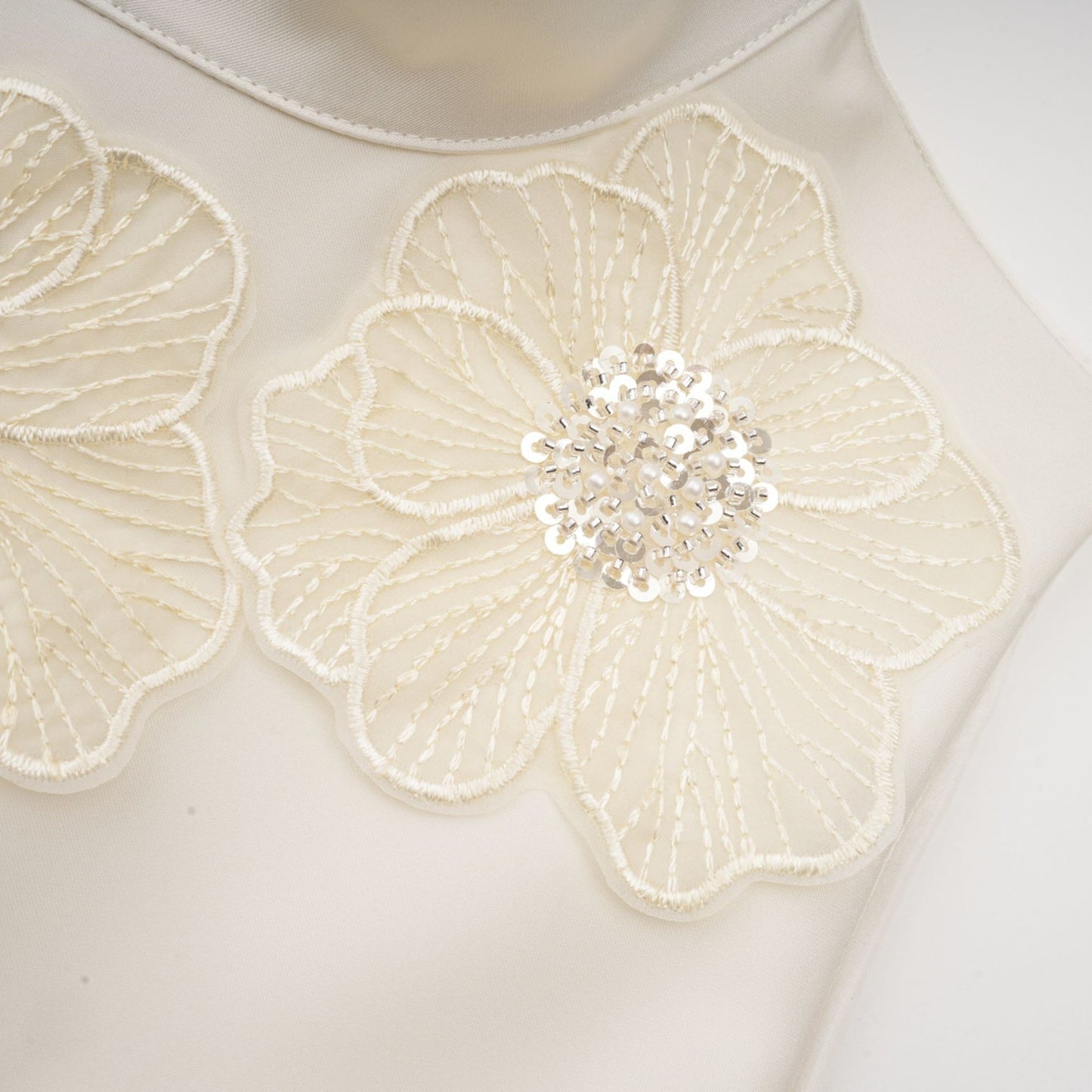 A white sleeveless midi dress with floral applique details named Emilie