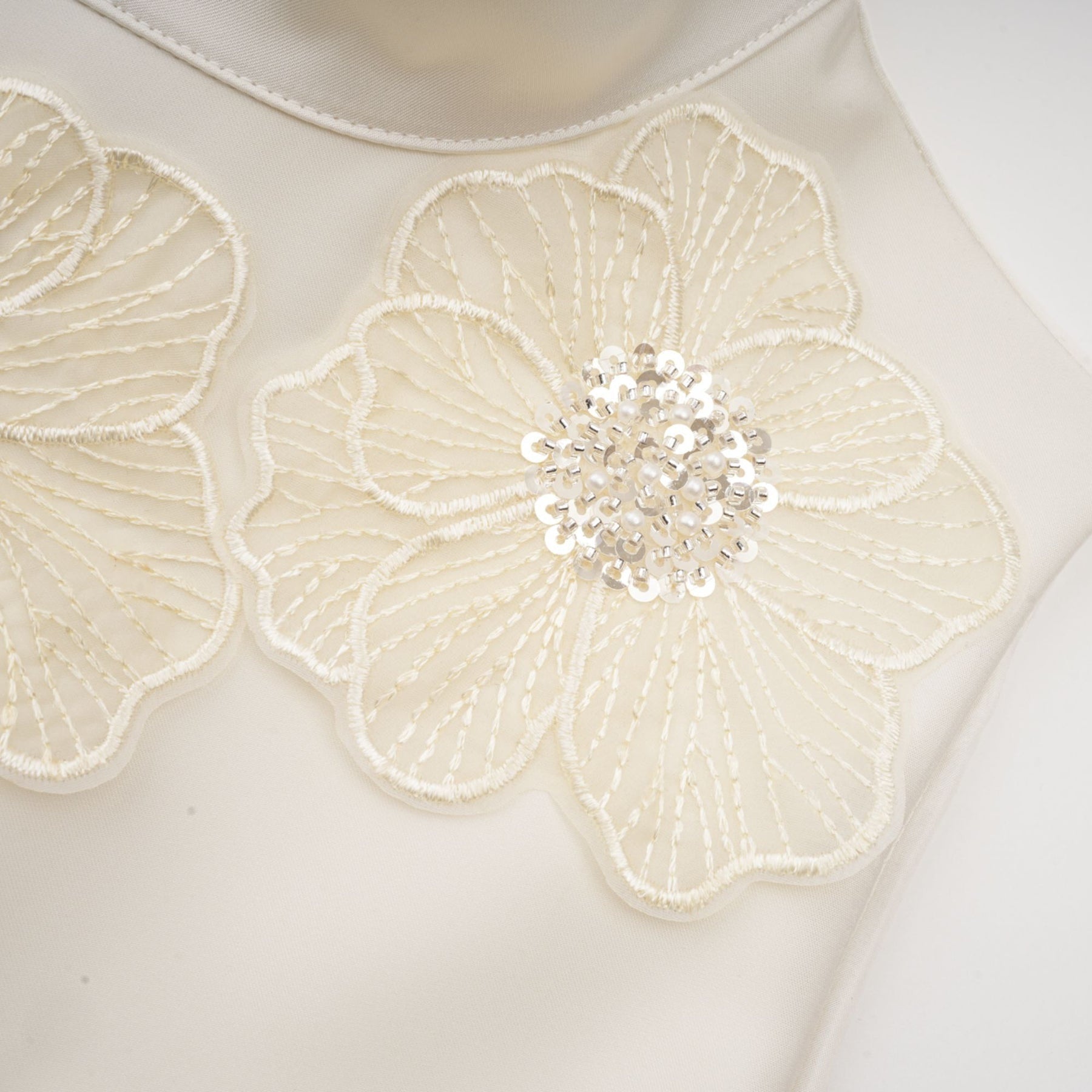 A white sleeveless midi dress with floral applique details named Emilie