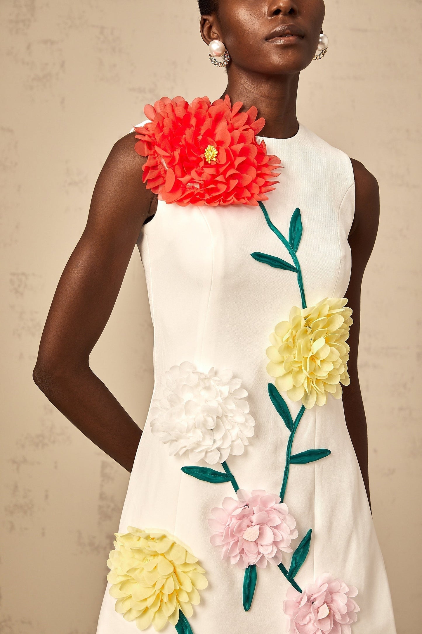 A white sleeveless mini dress with 3D floral petal details featuring a Veronique design