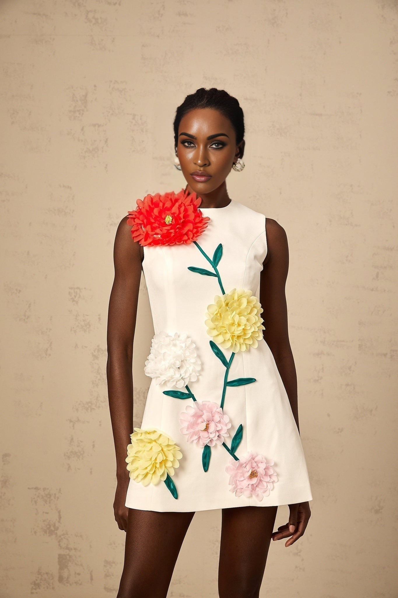 A white sleeveless mini dress with 3d floral petal details named Veronique