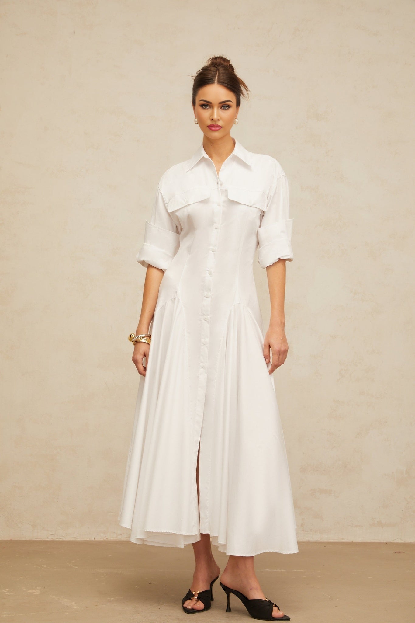 A white sleeveless shirt dress with a front slit and shirred waist detail