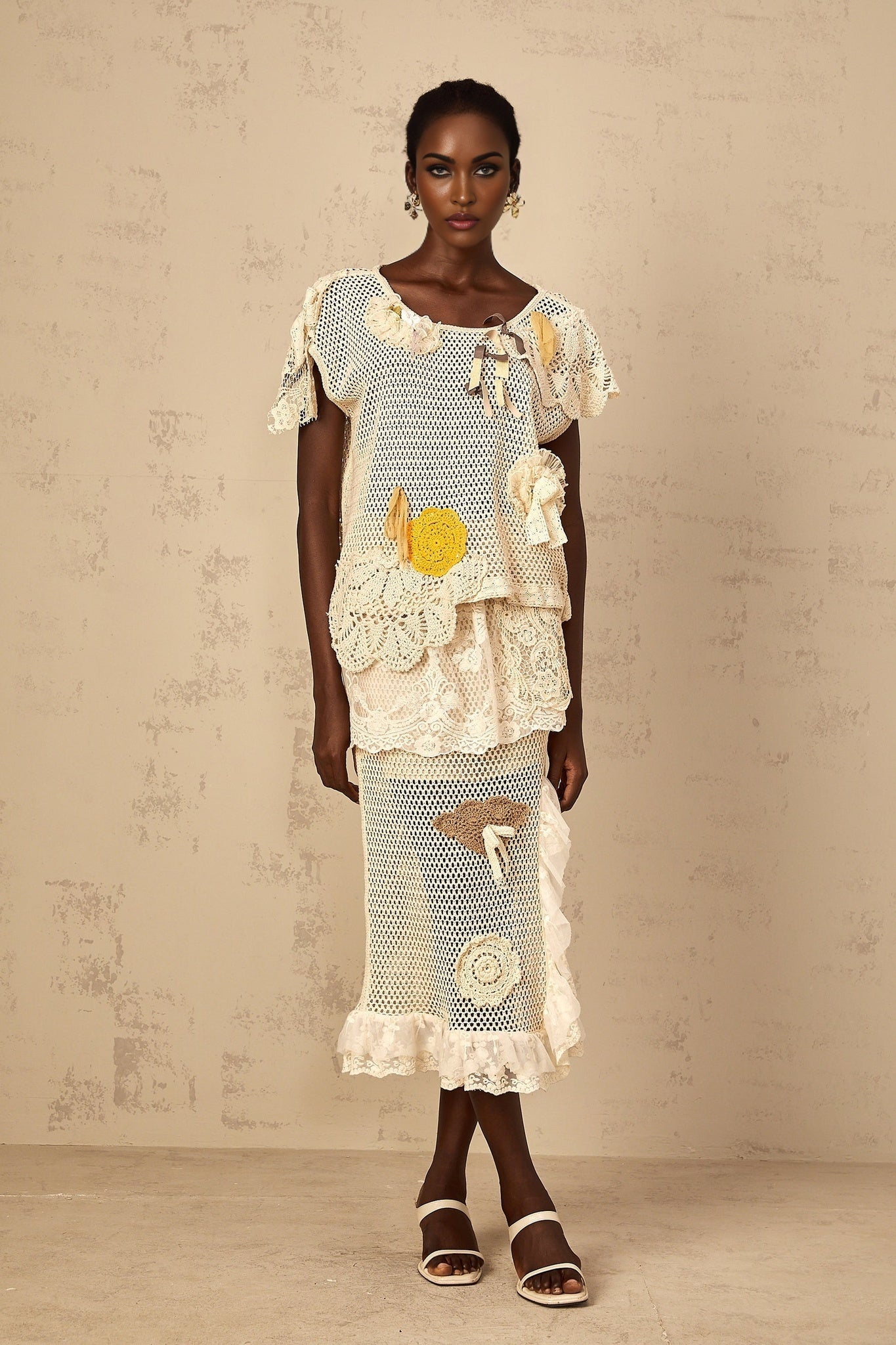 A white sleeveless top with a delicate lace panel and crochet knit detailing