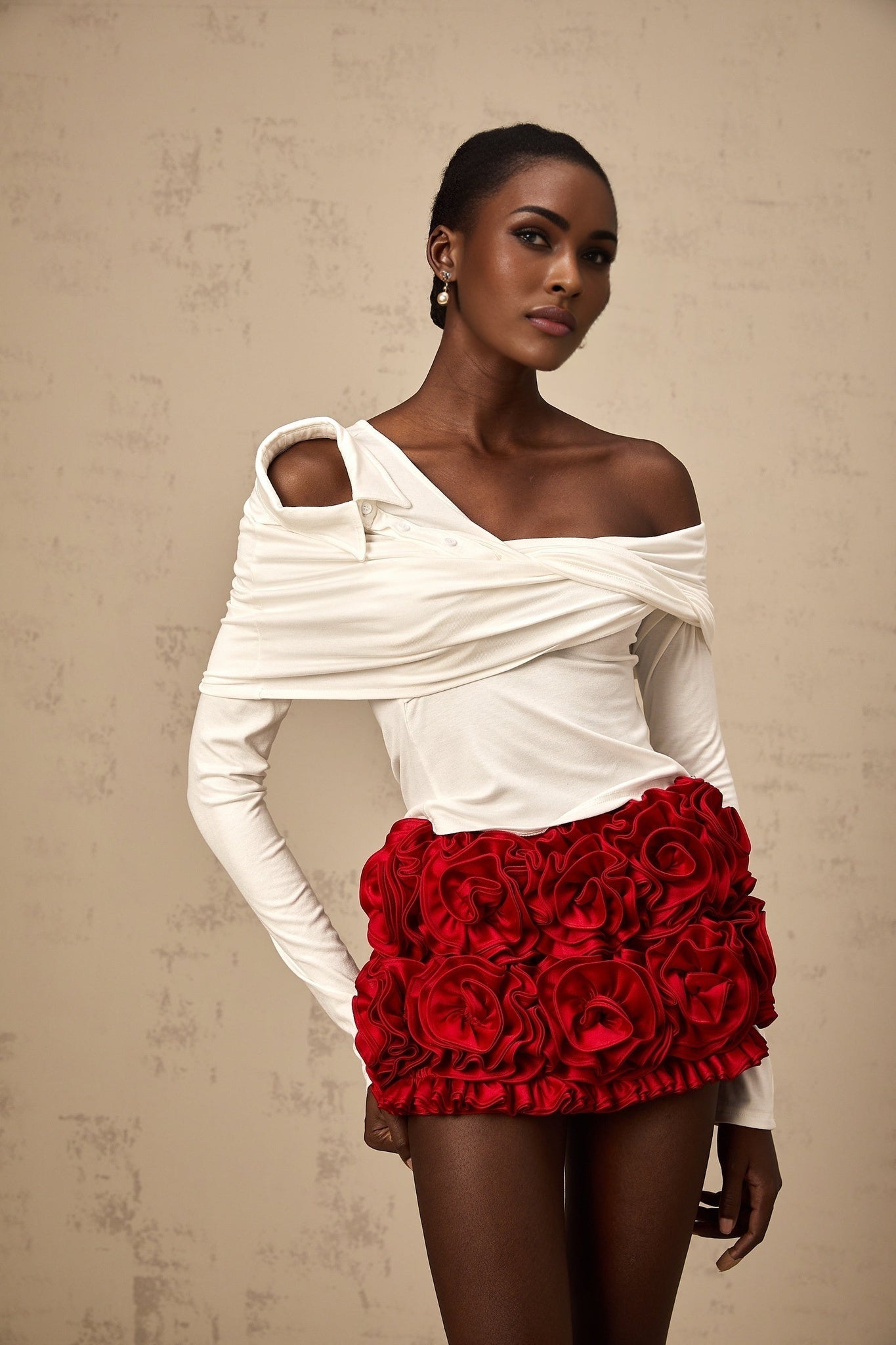 A white sleeveless top with an asymmetric neckline and twisted fabric detail across the front