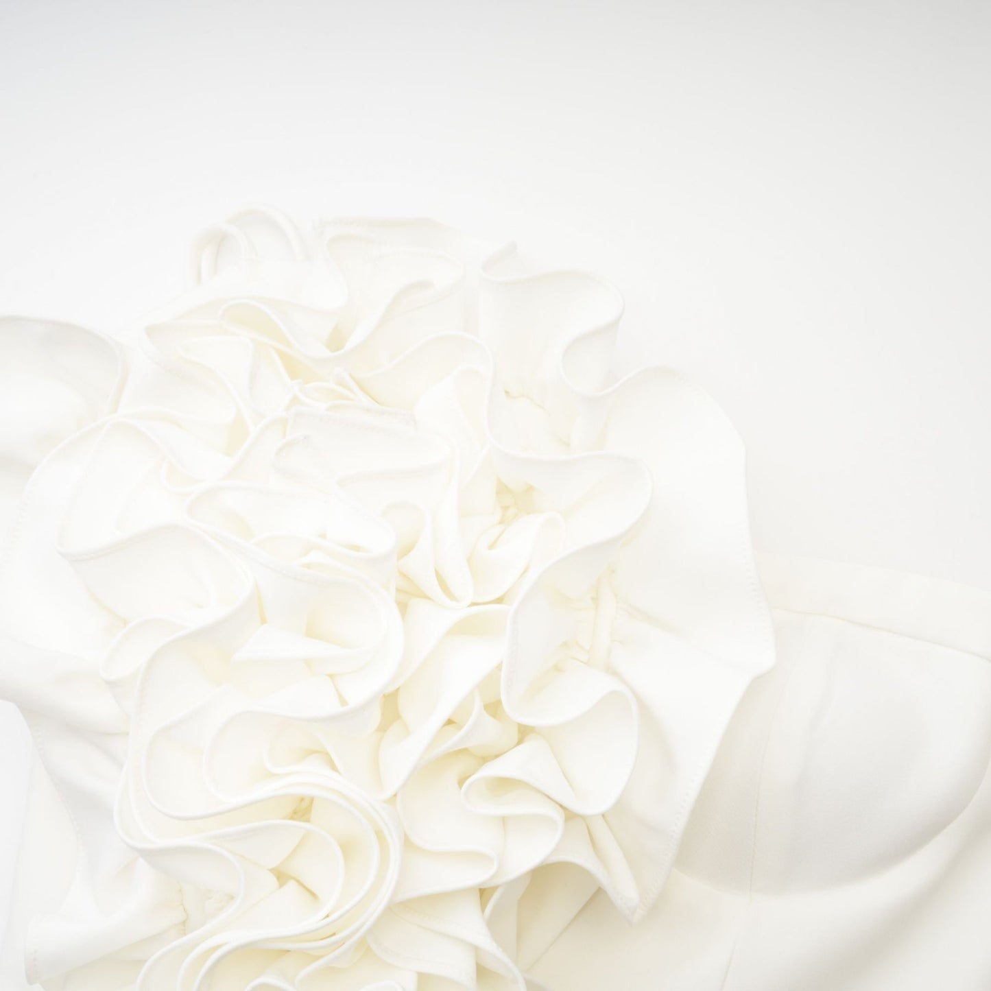 A white sleeveless top with delicate floral applique details adorning the fabric