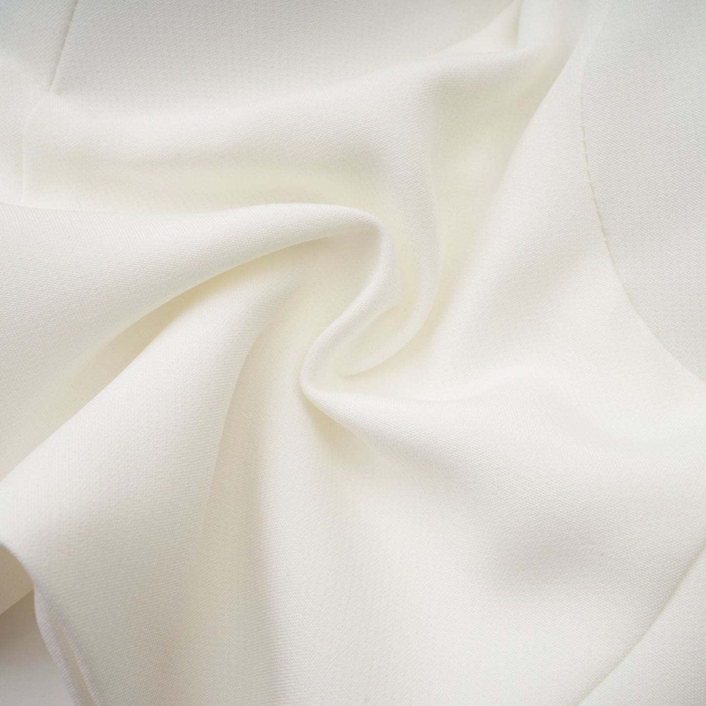A white sleeveless top with delicate floral applique details adorning the fabric