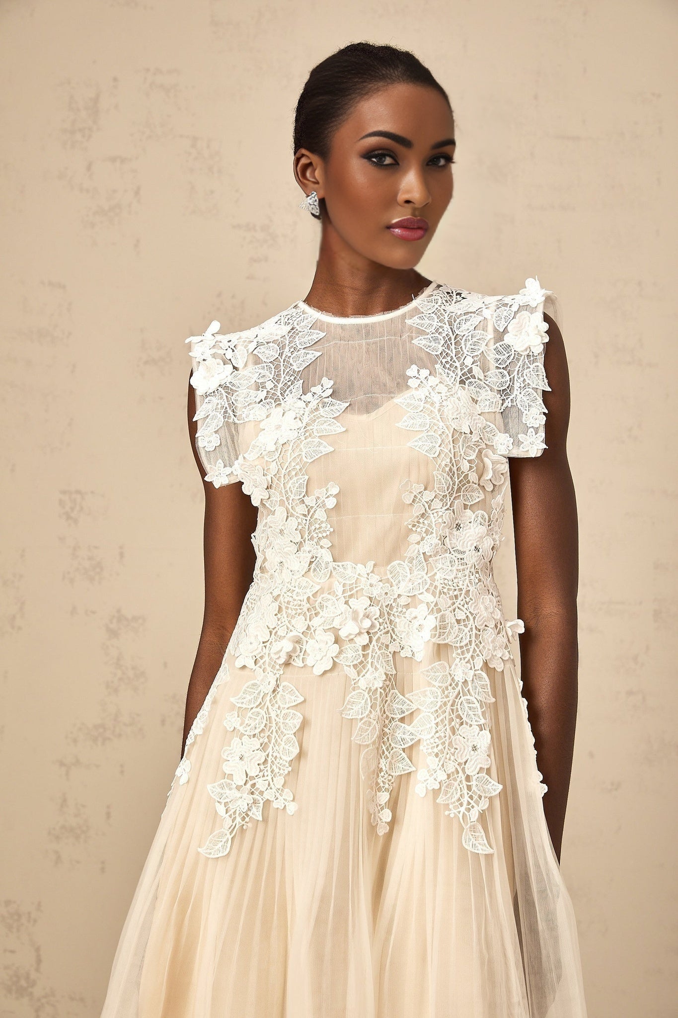 A white tulle midi dress with delicate flower appliques scattered across the bodice and skirt featuring a sleeveless design and a flowy silhouette