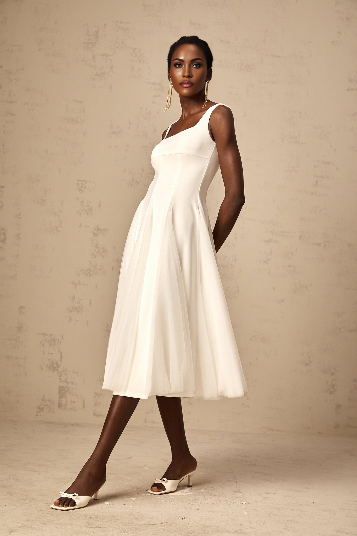 A white tulle midi dress with godet inserts featuring a fitted bodice and flared skirt named Danielle