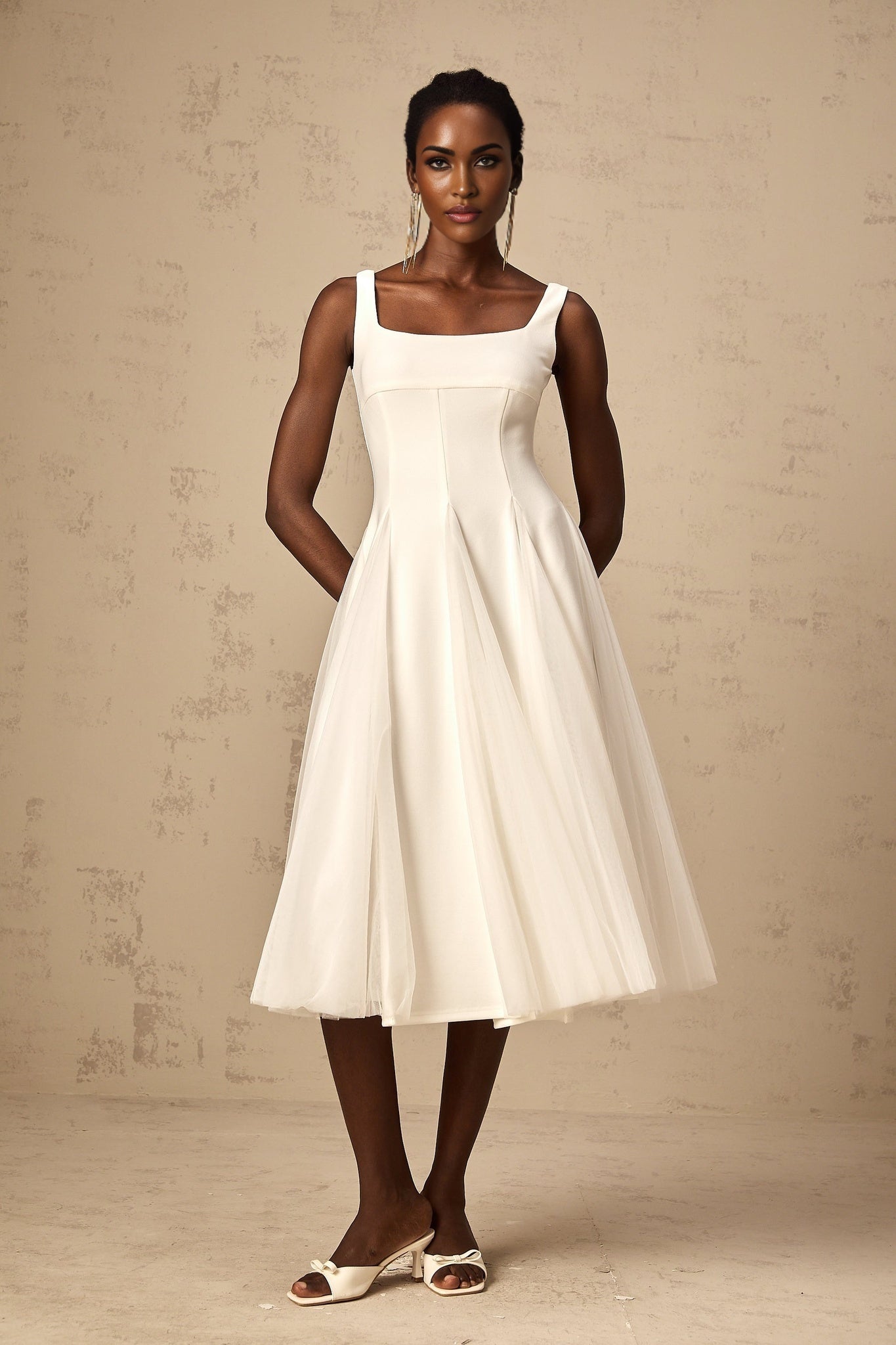 A white tulle midi dress with godet inserts featuring a fitted bodice and flared skirt