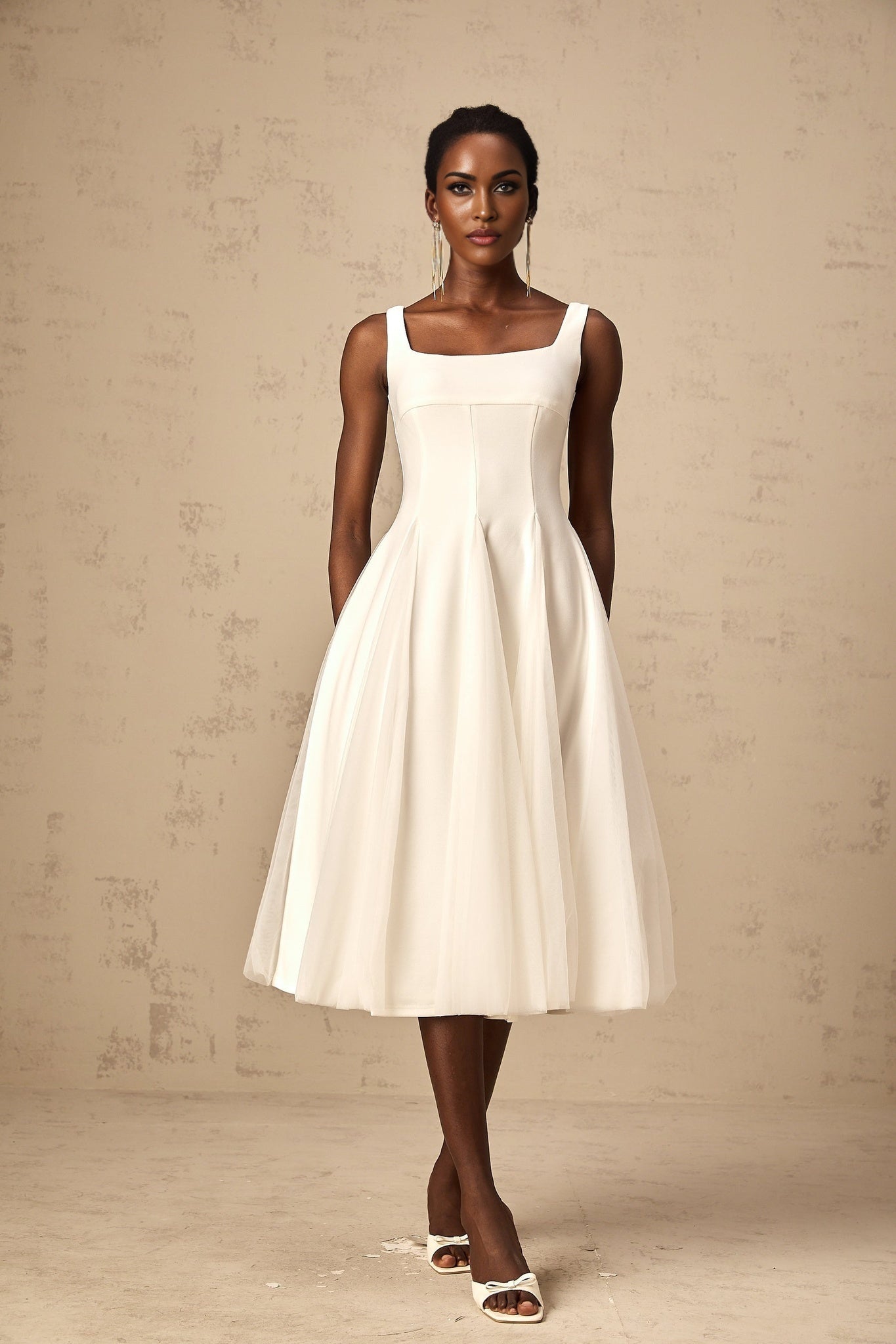 A white tulle midi dress with godet inserts featuring a flared silhouette and delicate fabric named Danielle