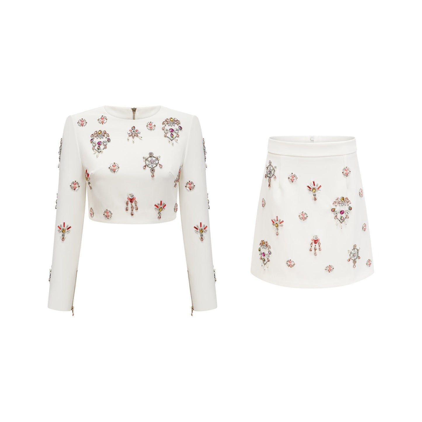 A white twopiece outfit consisting of a top and skirt adorned with crystal embellishments The set features a matching design and is named Jeanne