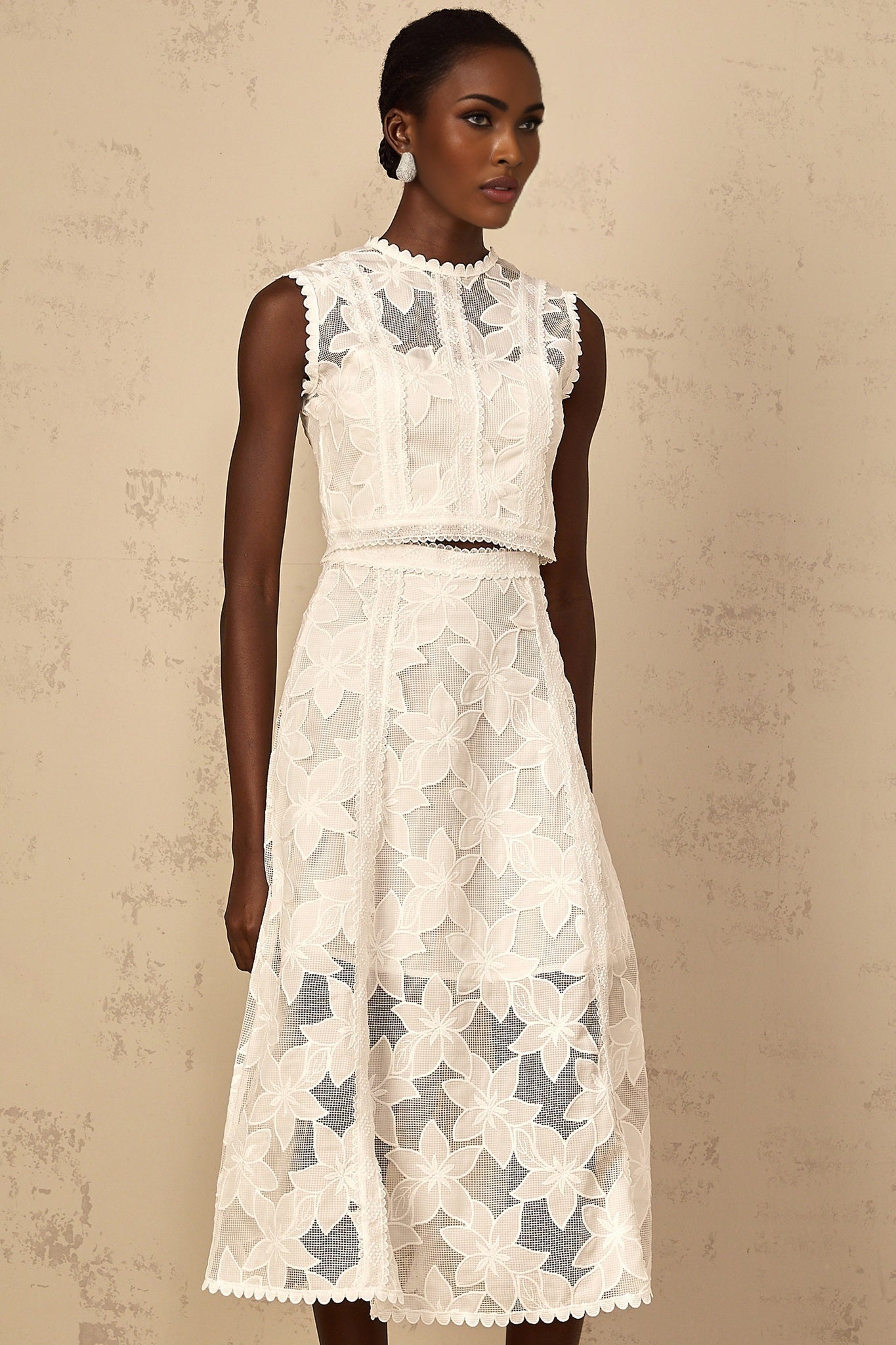 A white twopiece outfit consisting of a top and skirt with floral embroidery details named Mailys