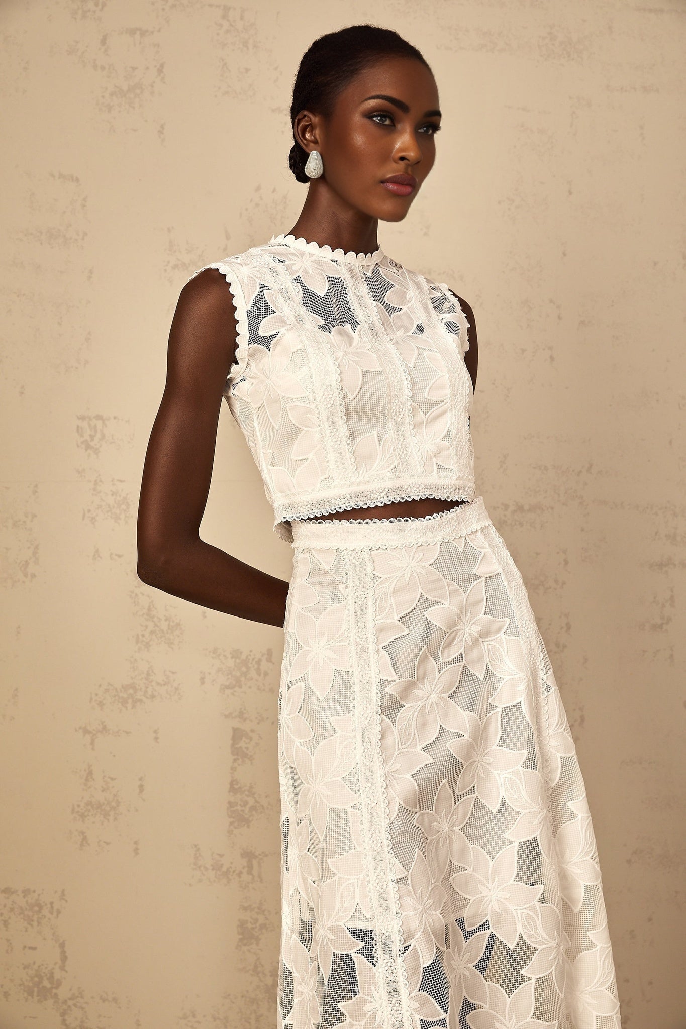 A white twopiece outfit featuring a top and skirt with floral embroidery details named Mailys