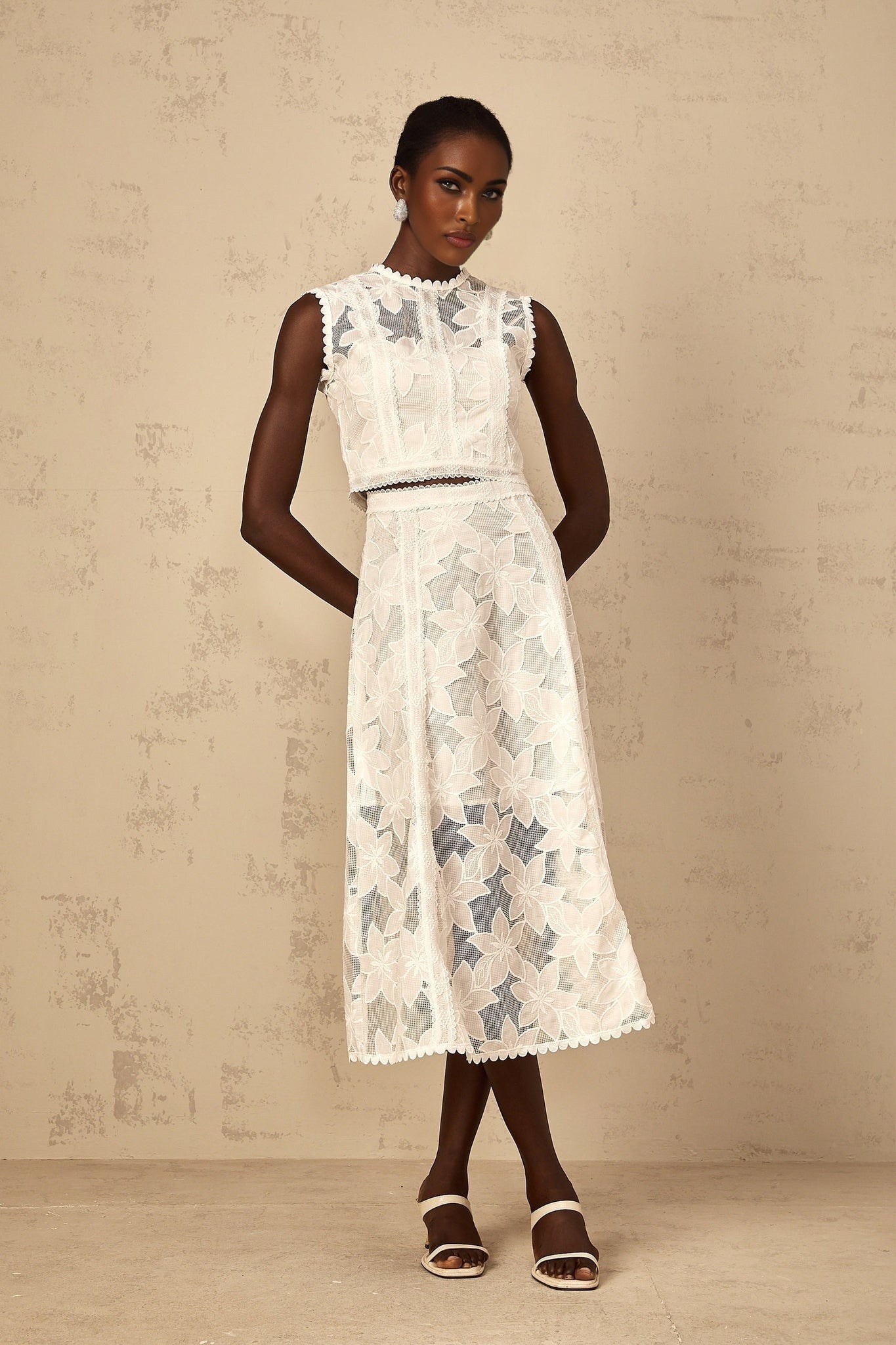 A white twopiece outfit featuring a top and skirt with floral embroidery named Mailys The set has delicate flower patterns stitched onto the fabric creating an elegant and feminine look