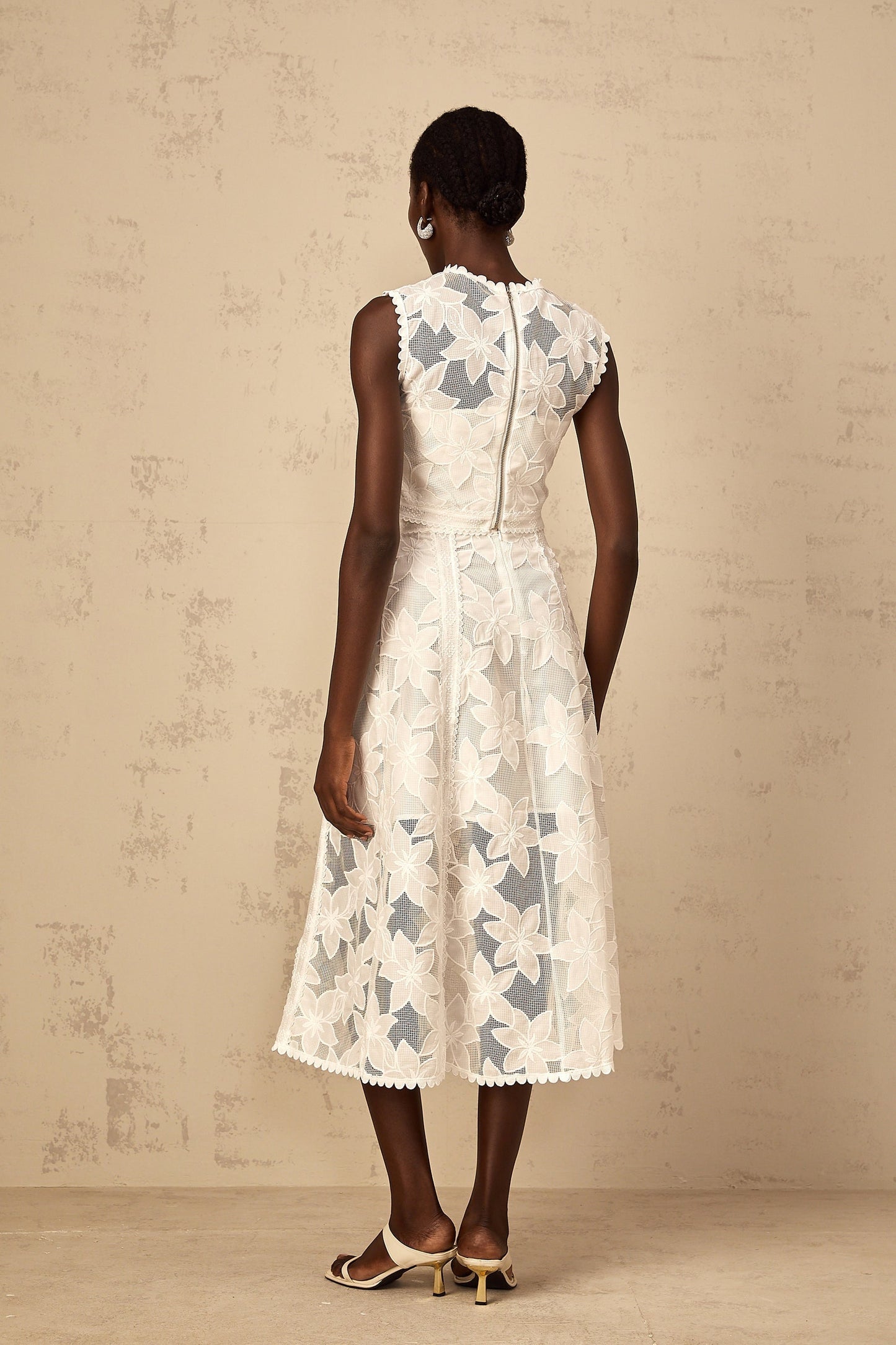 A white twopiece outfit featuring a top and skirt with floral embroidery named Mailys