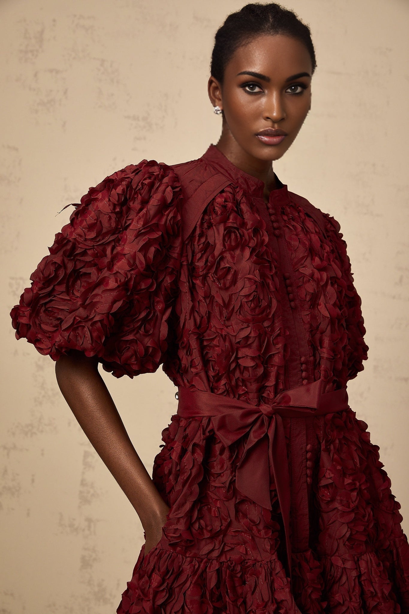 A winered mini dress with three dimensional petallike puff details featuring a design by Segolene