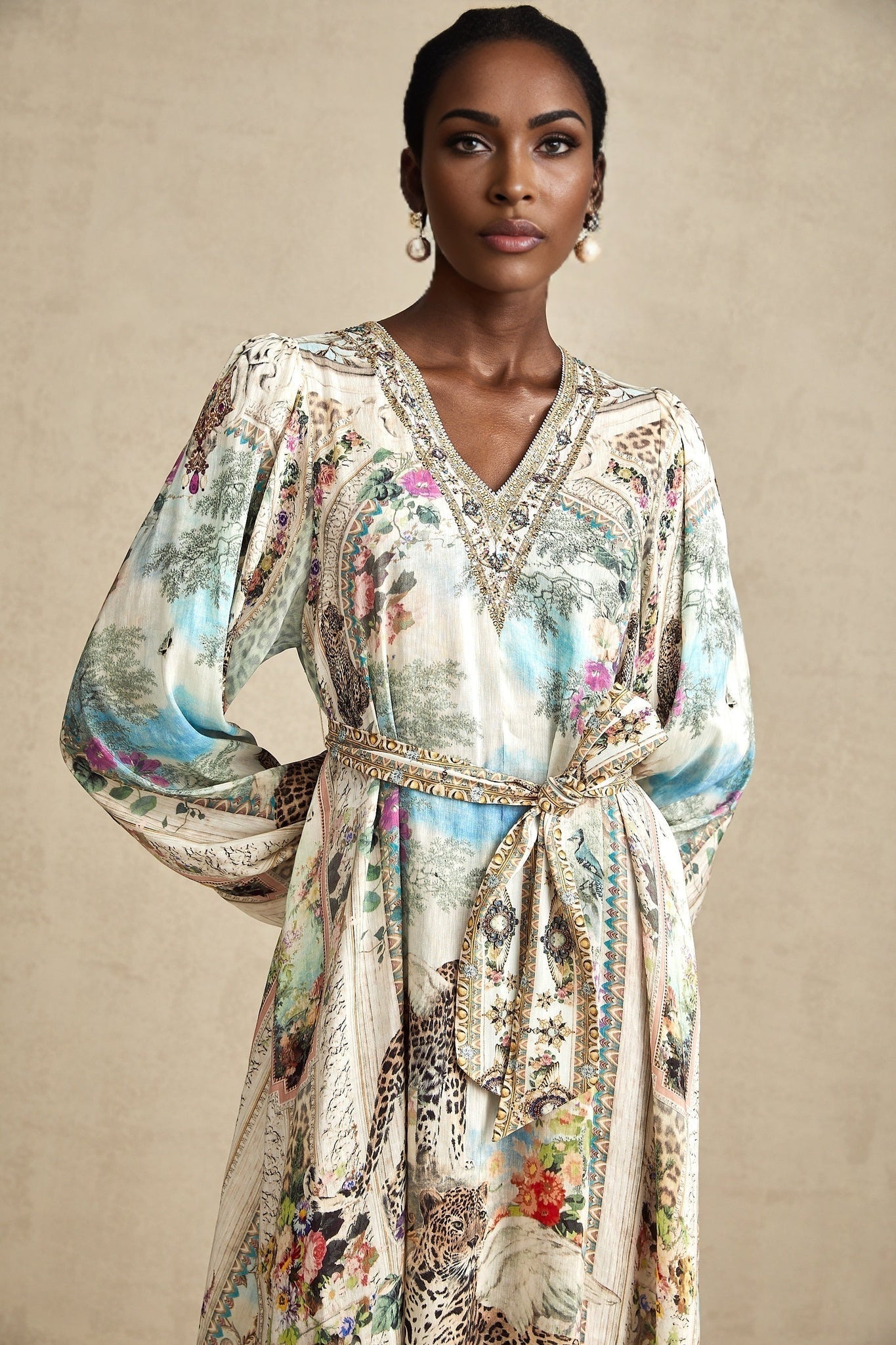 A woman wearing a belted midi dress with a V neckline in a sophisticated style