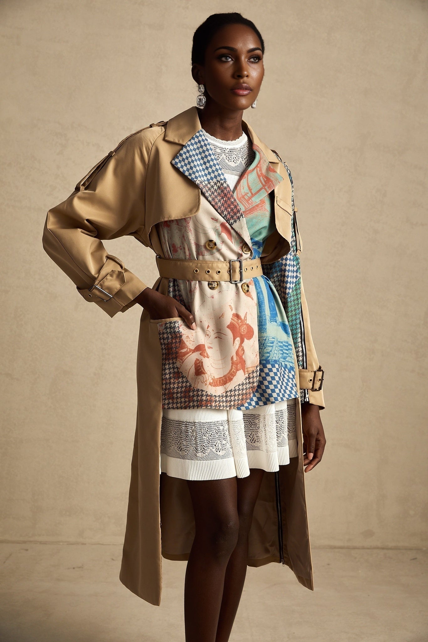 A woman wearing a belted trench coat with contrasting colors and a printed design The coat features a classic trench style with lapels and a tie belt at the waist