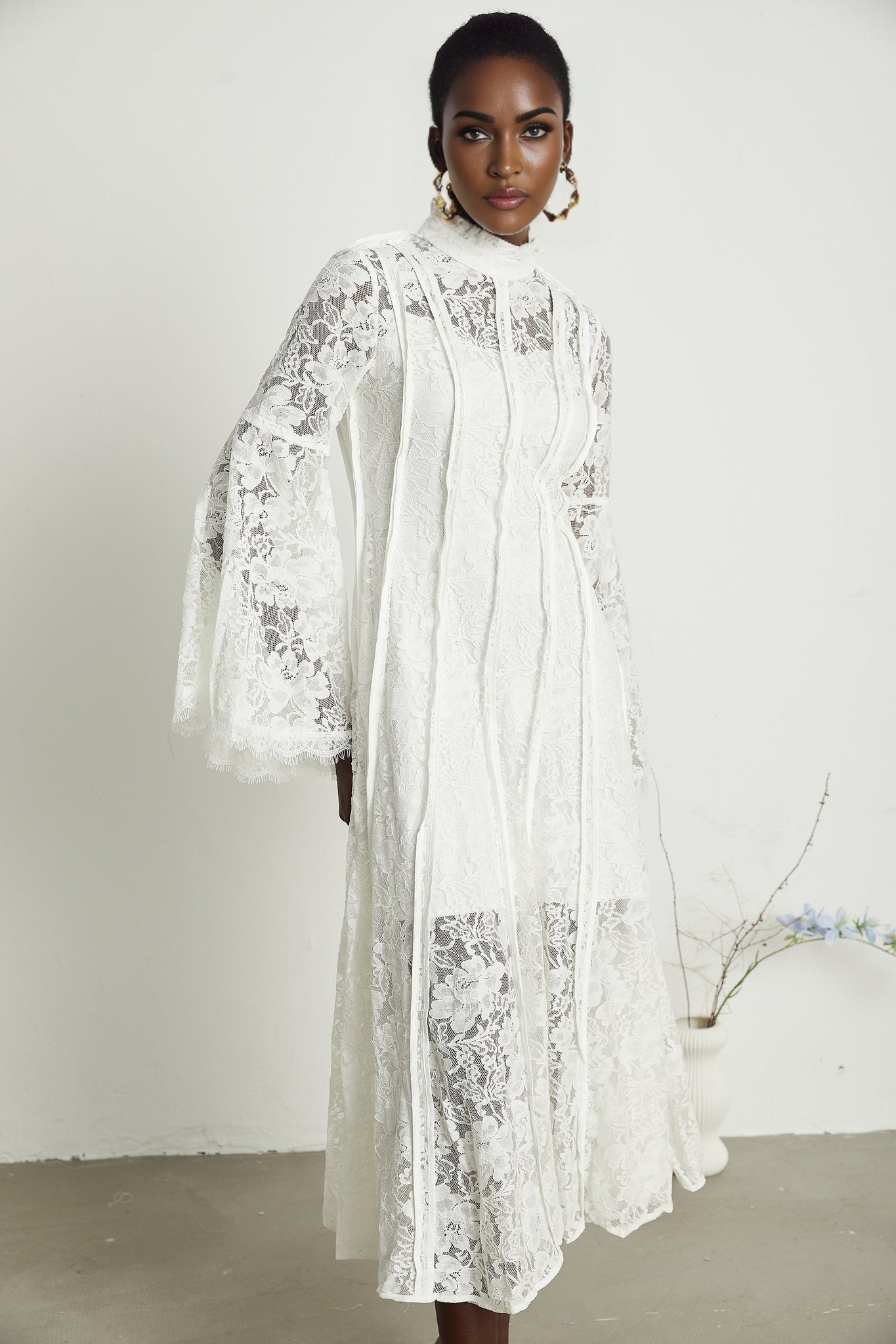 A woman wearing a black lace midi dress with cutout details designed by Celine