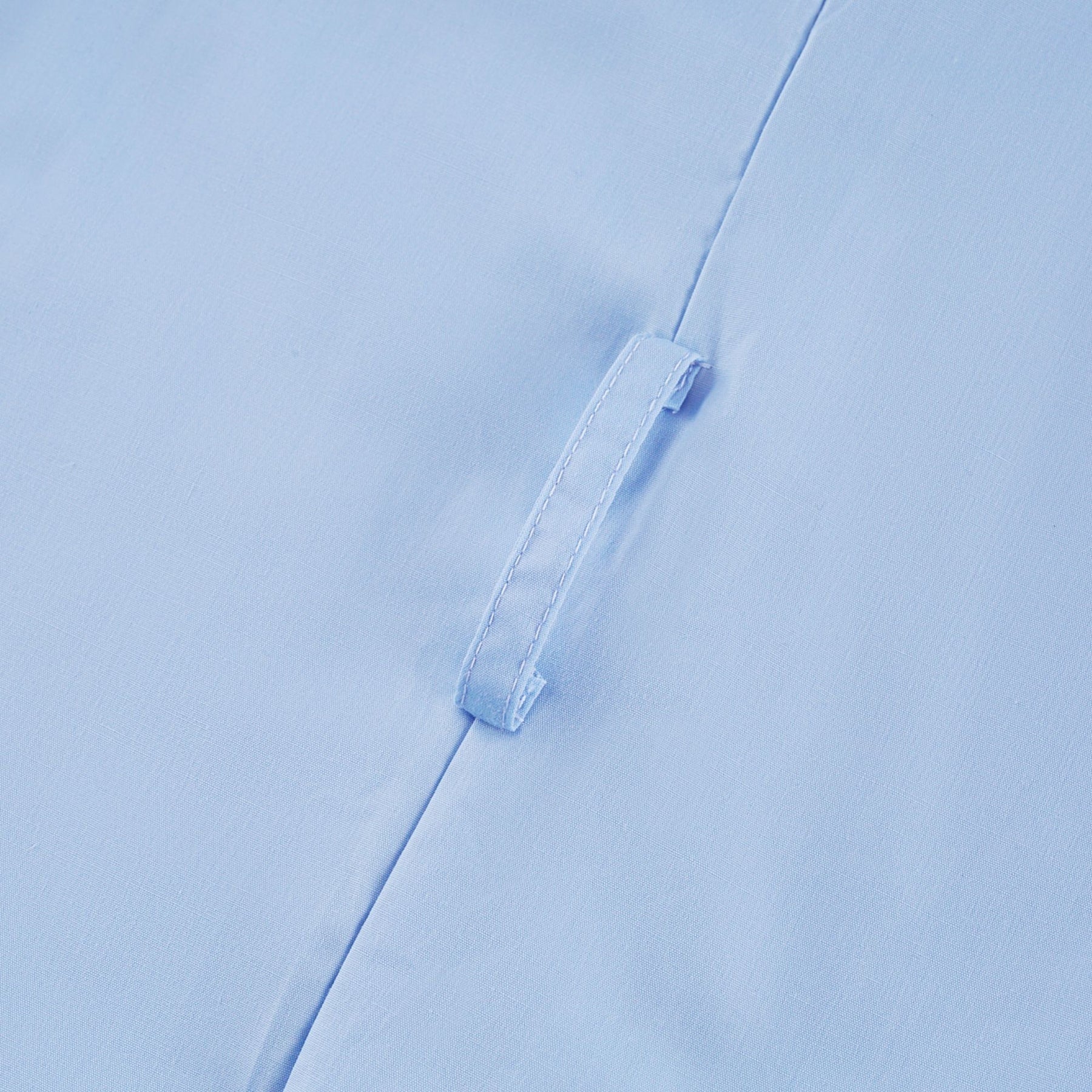 A woman wearing a black offshoulder midi dress with tiered ruffles standing against a plain background