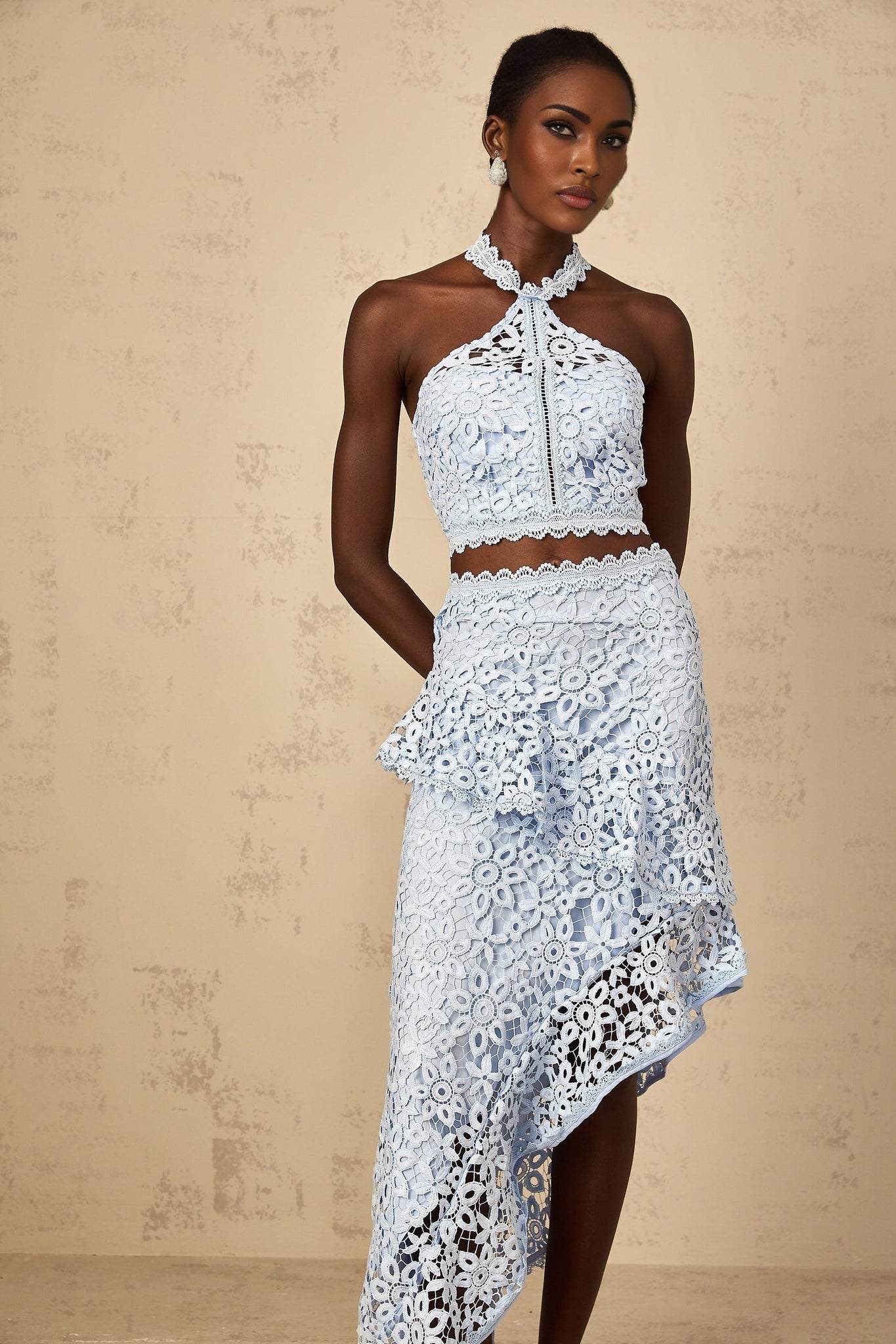 A woman wearing a blue corded lace matching set consisting of a top and bottom garment by Bruyere