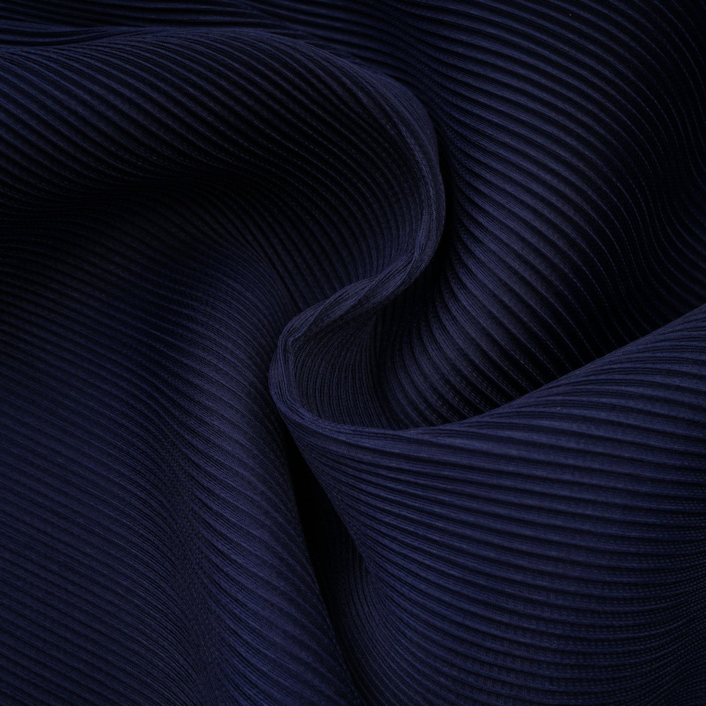 A woman wearing a blue patterned cape and matching skirt set The cape has a creased texture and the skirt features the same print The outfit is called Debbie and has a coordinated look