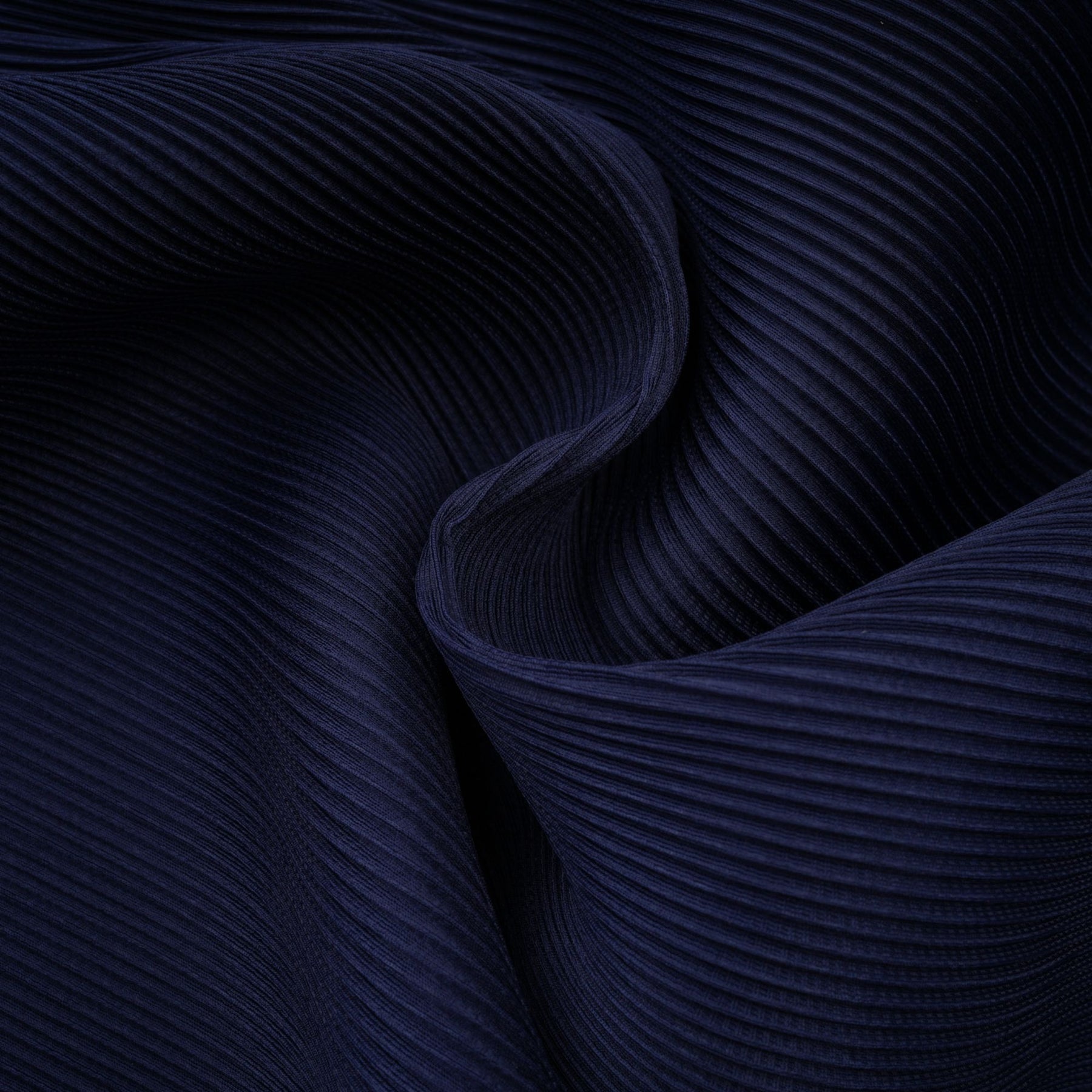 A woman wearing a blue patterned cape and matching skirt set The cape has a creased texture and the skirt features the same print The outfit is called Debbie and has a coordinated look