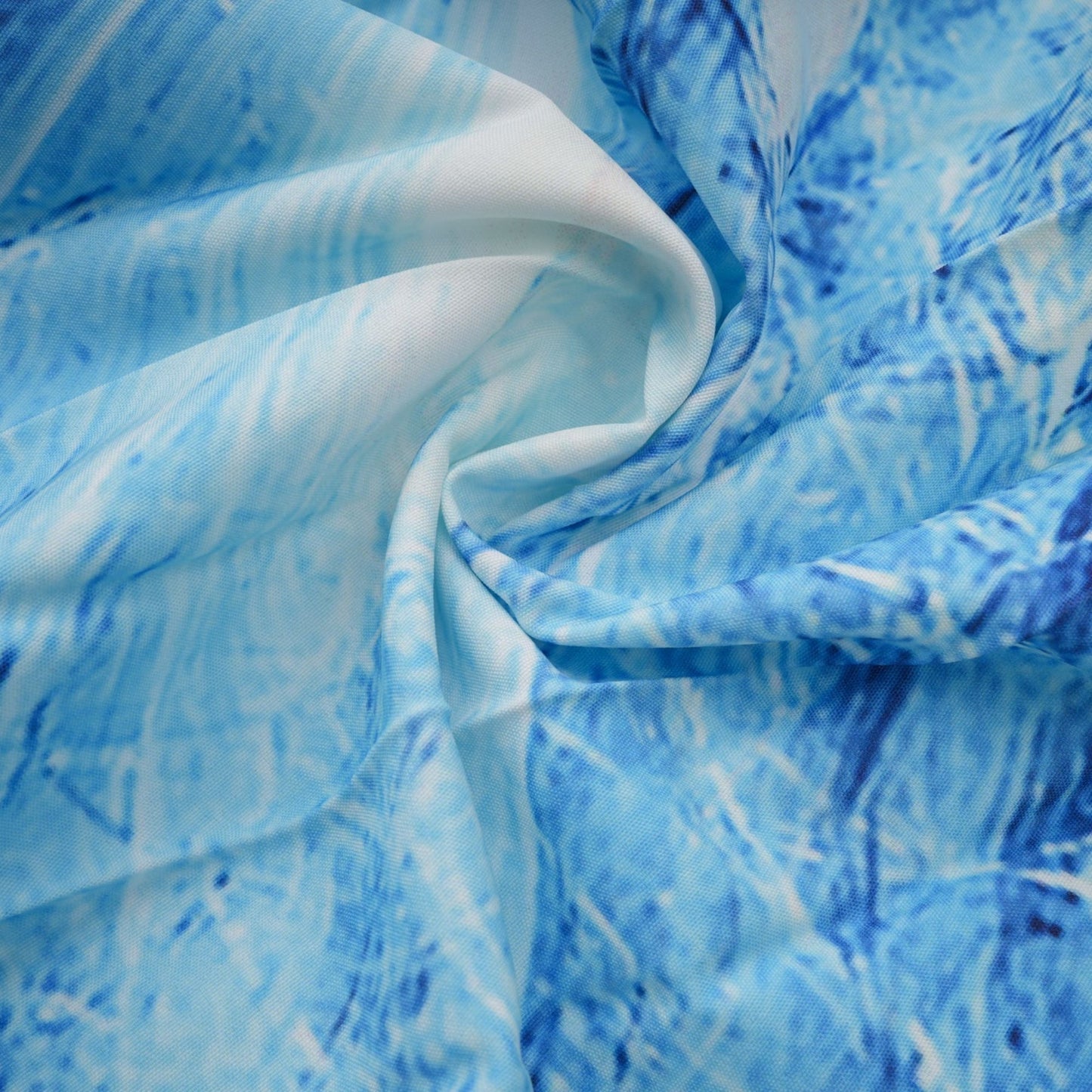 A woman wearing a blue patterned cape paired with a matching skirt featuring a crinkled texture and floral print design