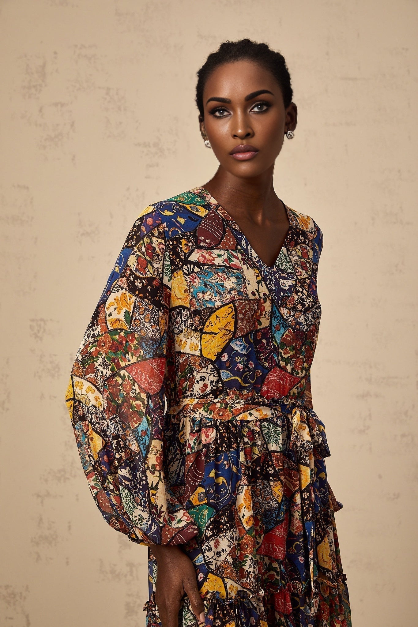 A woman wearing a brown bohemian style midi dress with shirring details and a flowy silhouette