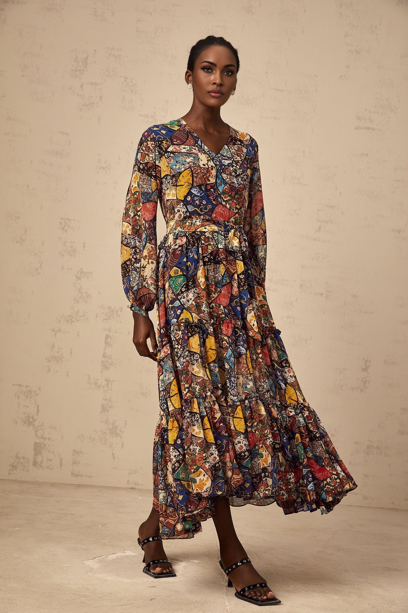 A woman wearing a brown bohemian style midi dress with shirring details standing in a relaxed pose