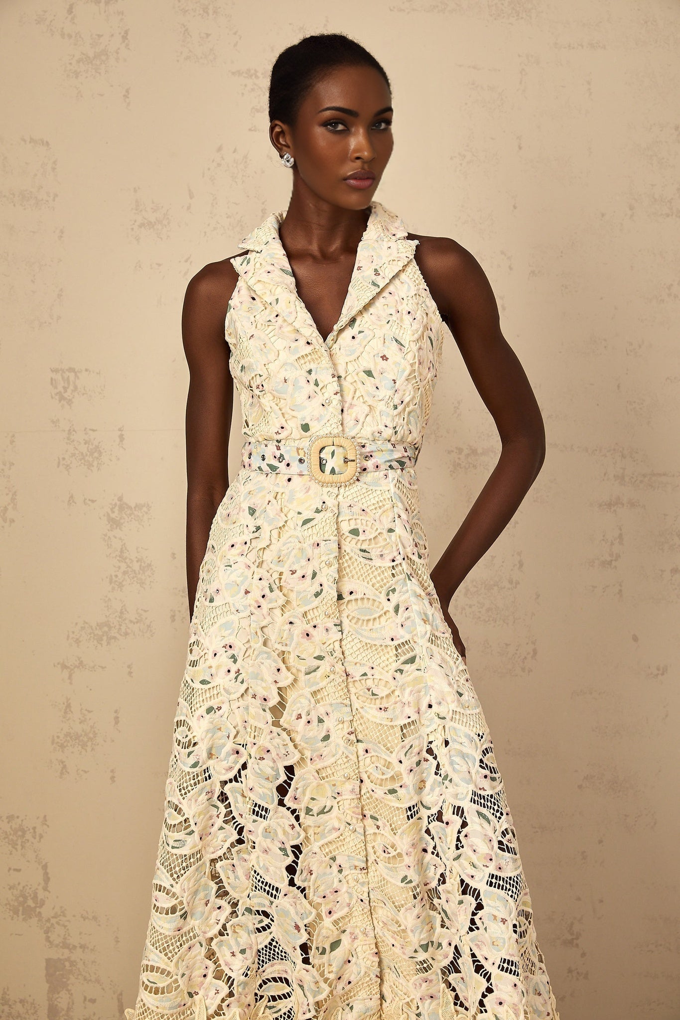 A woman wearing a floral embroidered midi dress with cutout details standing in a casual pose