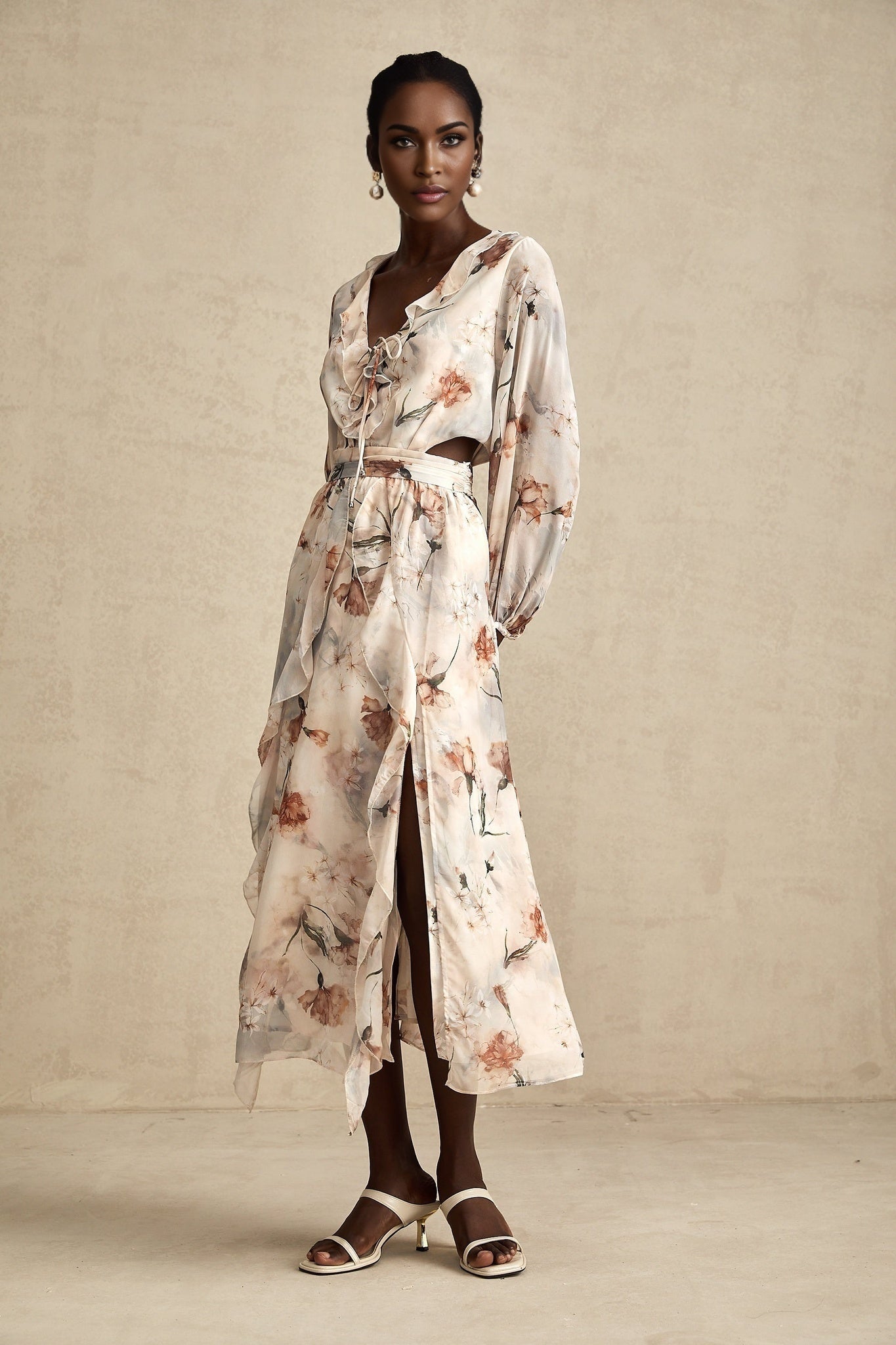 A woman wearing a floral print midi dress with an open waist design The dress features a Berengere style with a colorful floral pattern on a light background