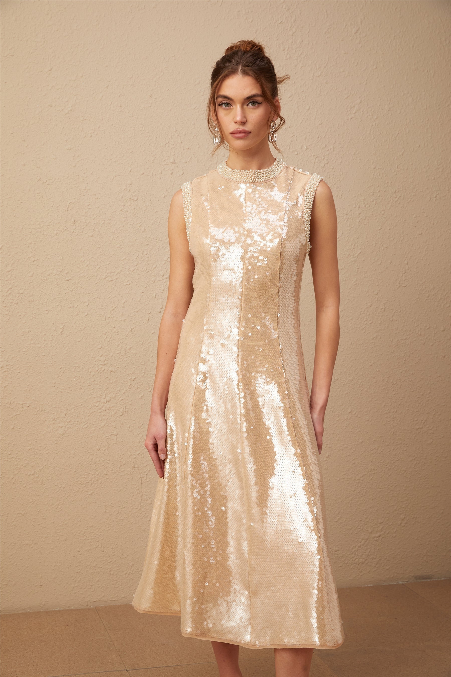 A woman wearing a glamorous midi dress adorned with shimmering sequins and faux pearls elegant evening gown with a feminine silhouette