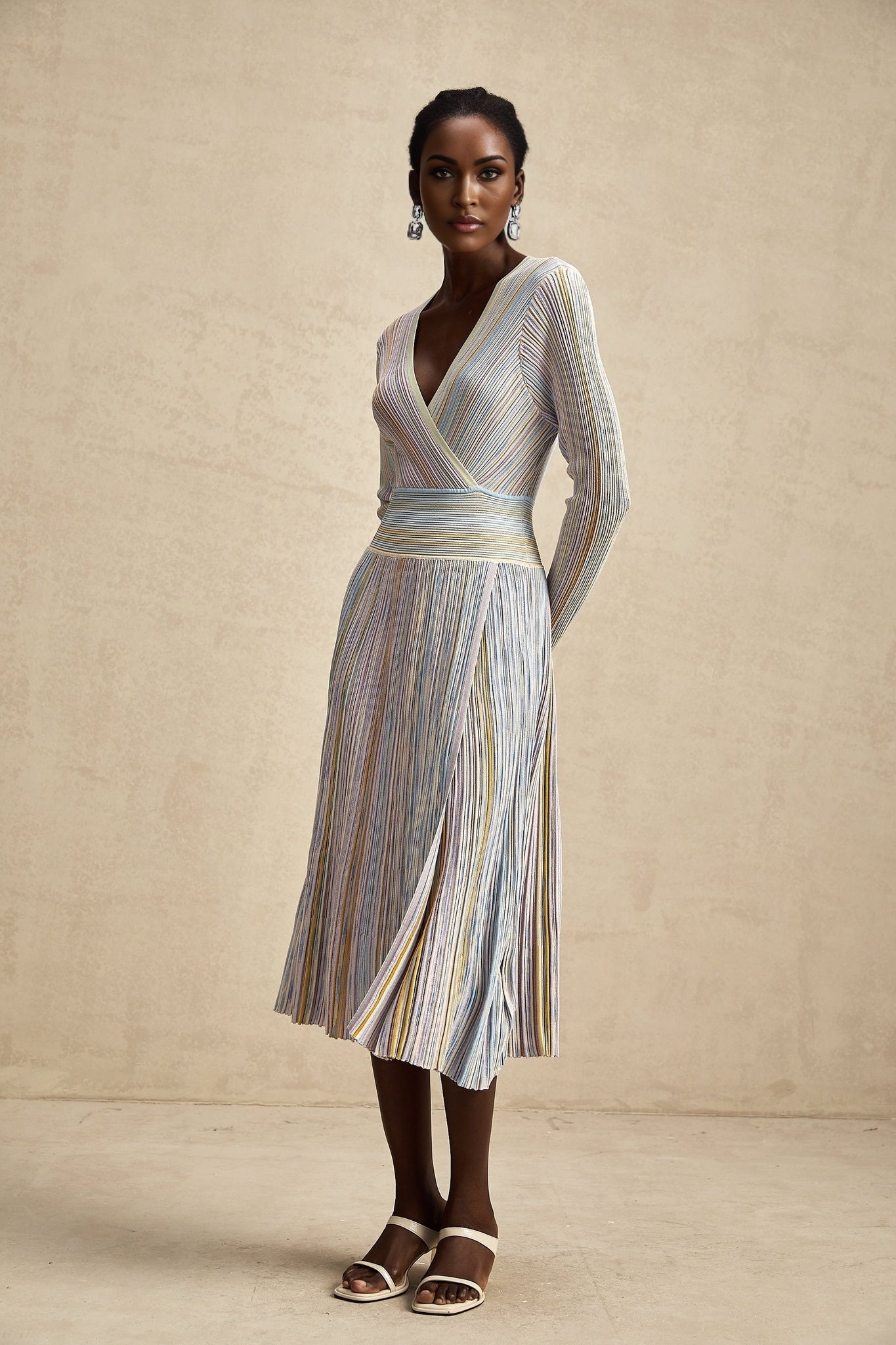 A woman wearing a kneelength knitted dress with vertical stripes in a style reminiscent of Amelie featuring a slim fit and midi length