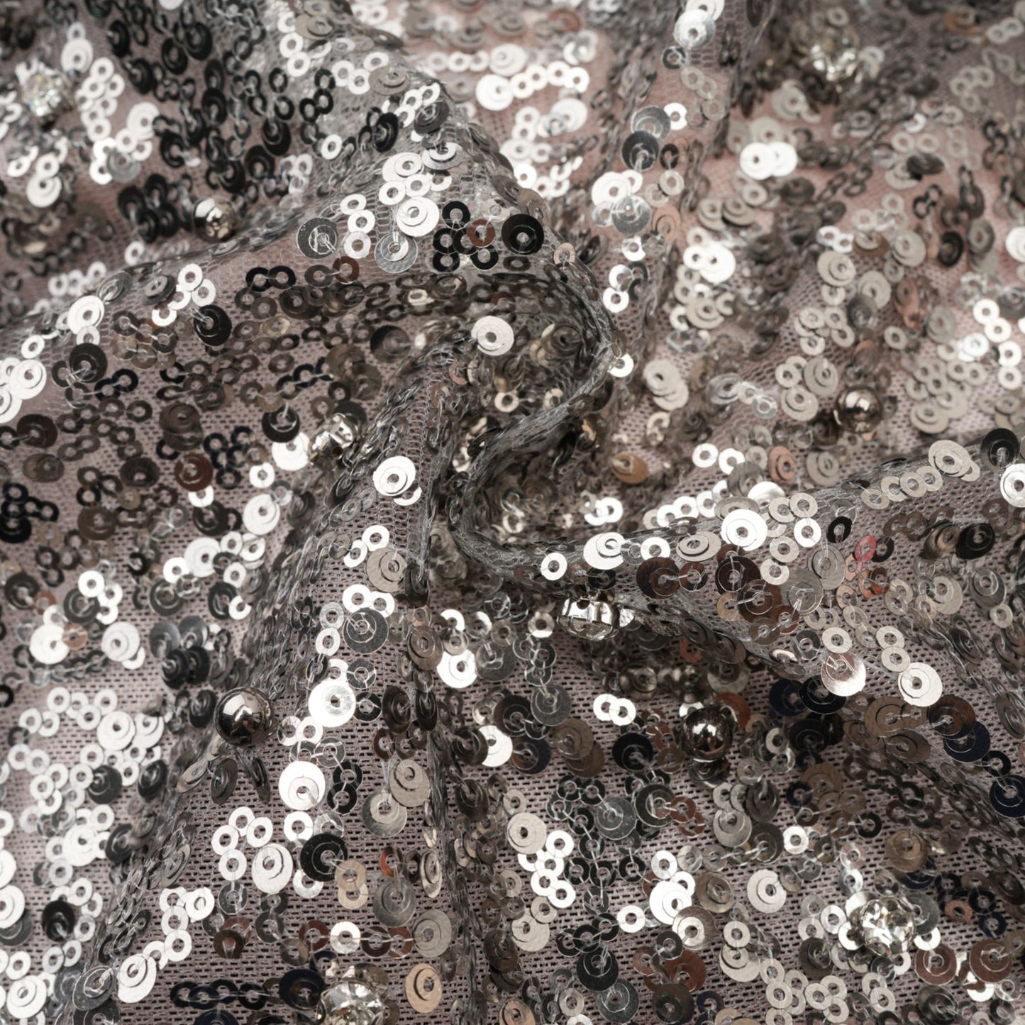 A woman wearing a long asymmetric maxi dress with sequin embellishments The dress has a shimmering effect and drapes elegantly on one side The model is posed to showcase the dresses unique cut and sparkly details