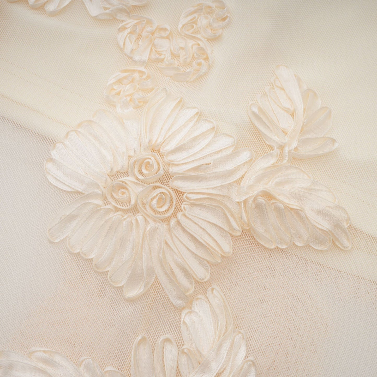 A woman wearing a long offshoulder maxi dress in neutral tones featuring embroidered details