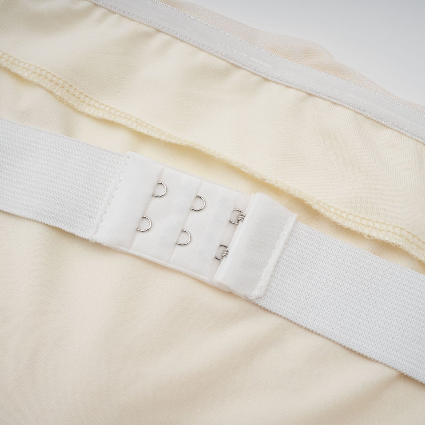 A woman wearing a long offshoulder maxi dress in neutral tones with embroidered details standing in a relaxed pose