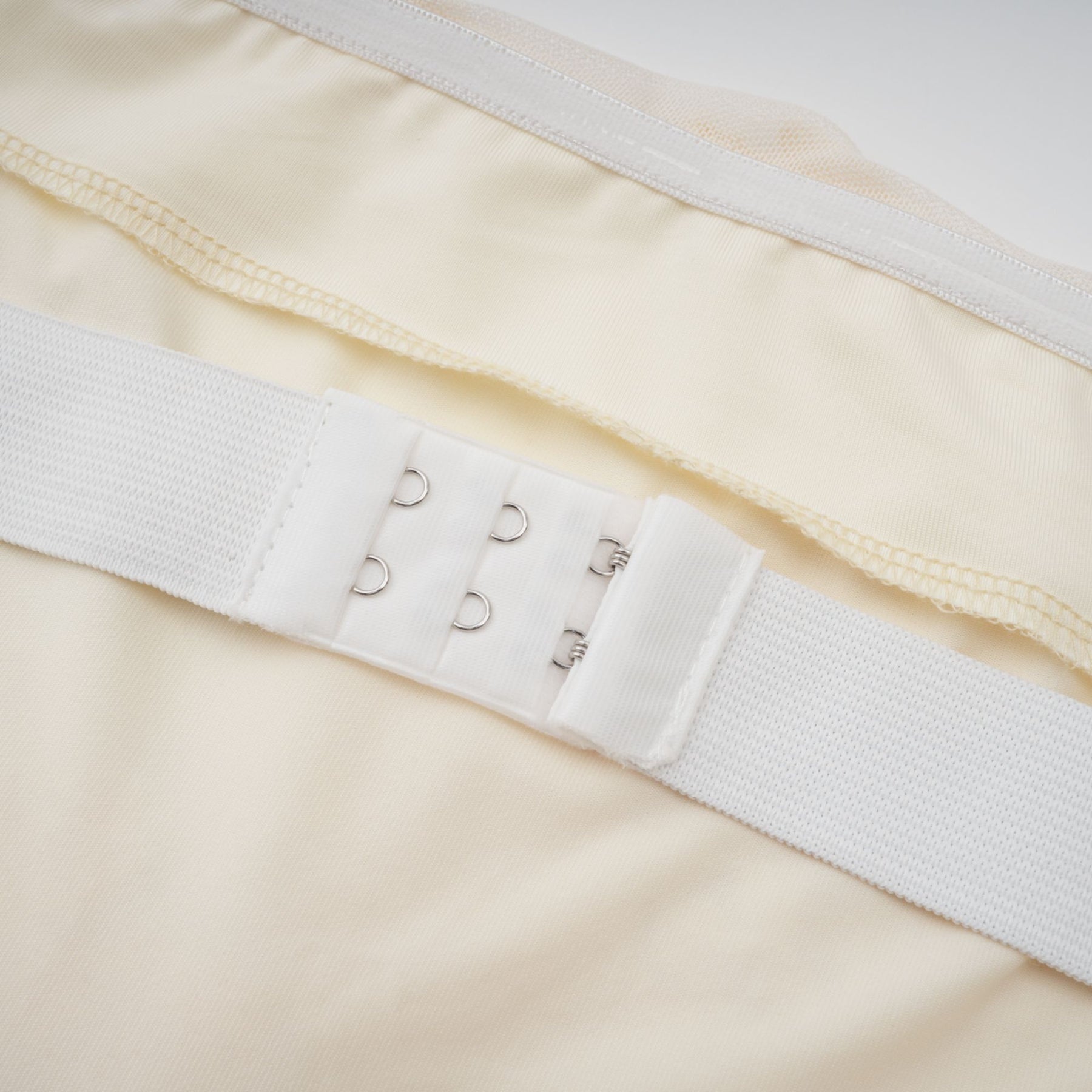 A woman wearing a long offshoulder maxi dress in neutral tones with embroidered details standing in a relaxed pose