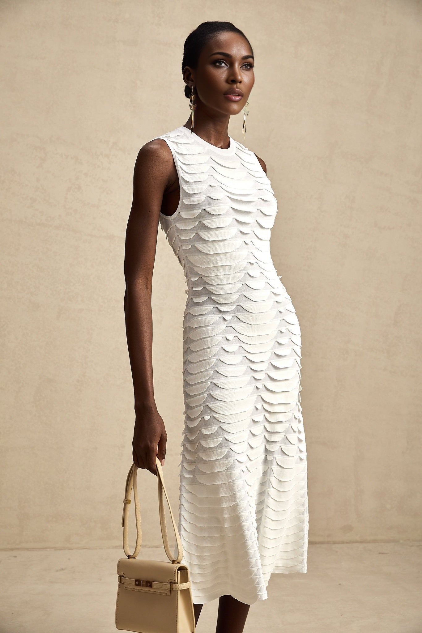 A woman wearing a long snakepattern midi dress with flared godet inserts that create an Aline silhouette