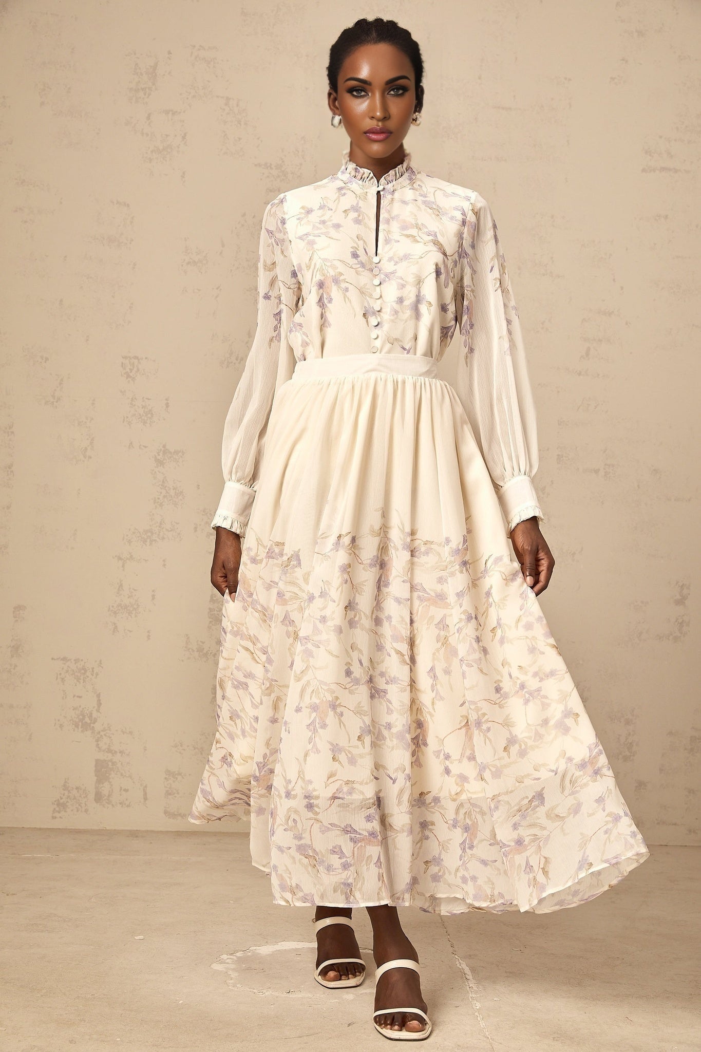 A woman wearing a matching floral set consisting of a frilled shirt and skirt in wisteria print with a Siena style