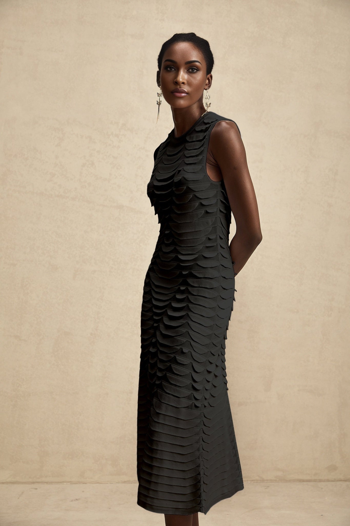 A woman wearing a midi length dress with a snake pattern design and godet skirt panels