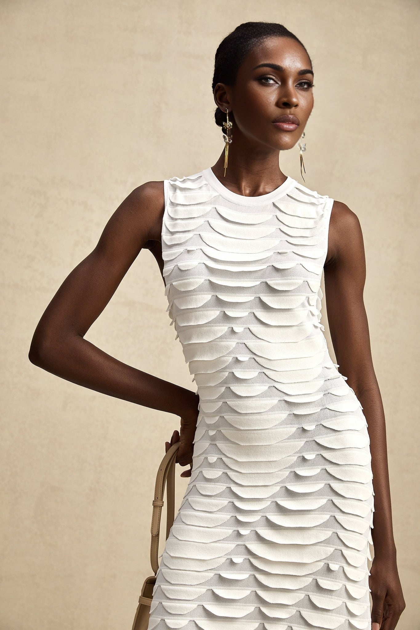 A woman wearing a midi length dress with a snake pattern print and godet skirt detail