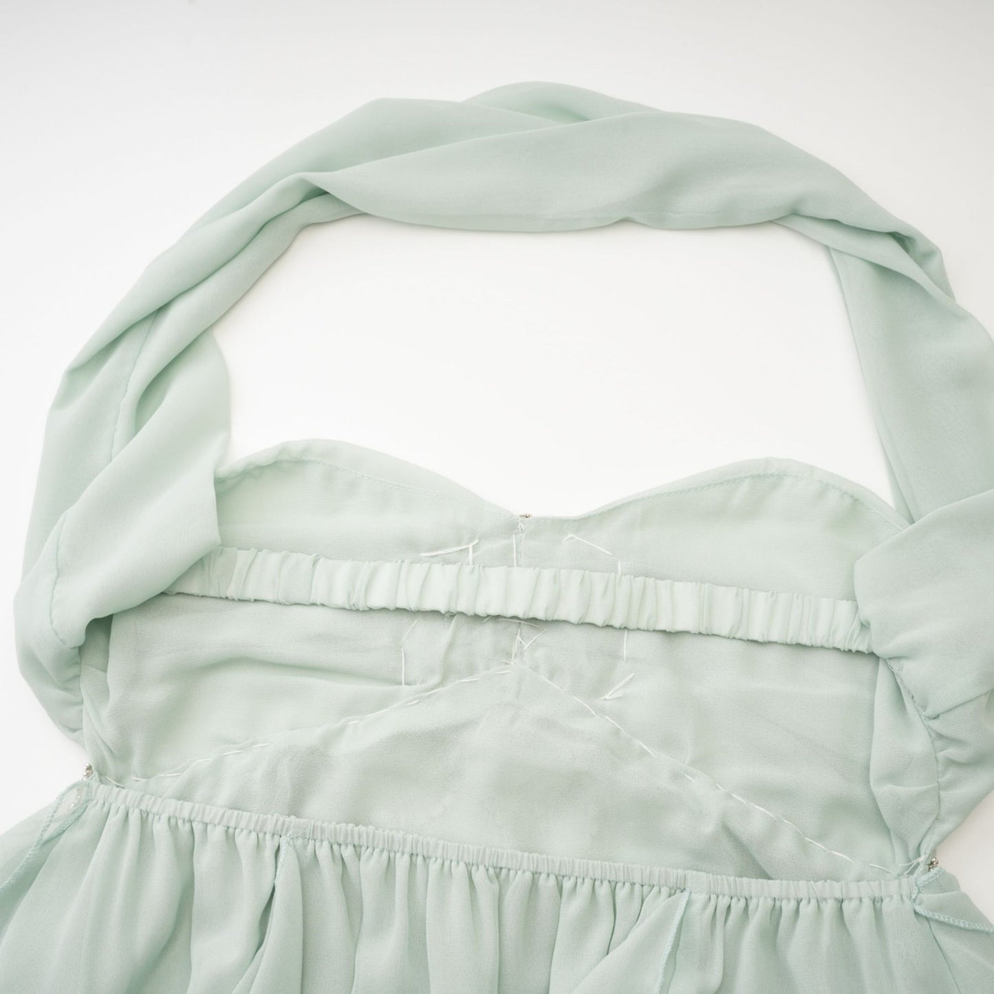 A woman wearing a midi length dress with ruffled details and embellishments The dress has a fitted bodice and flared skirt