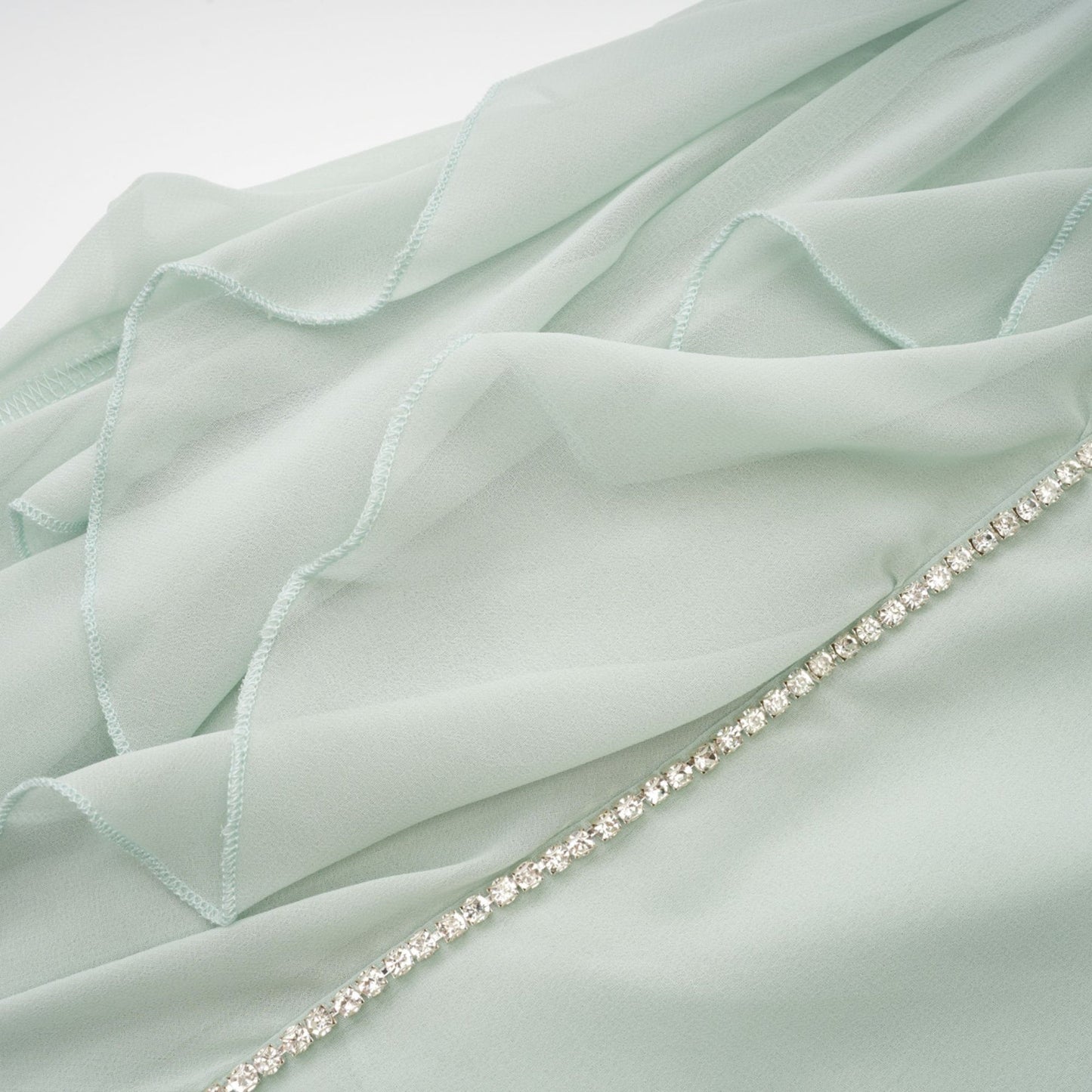 A woman wearing a midilength dress with ruffled details and embellishments named Salilah
