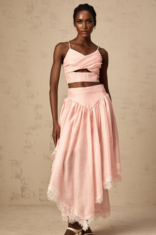 A woman wearing a pink matching set consisting of an asymmetric ruffled top and skirt The top has one shoulder and the skirt features ruffles The set is named Tamara and has a feminine stylish appearance