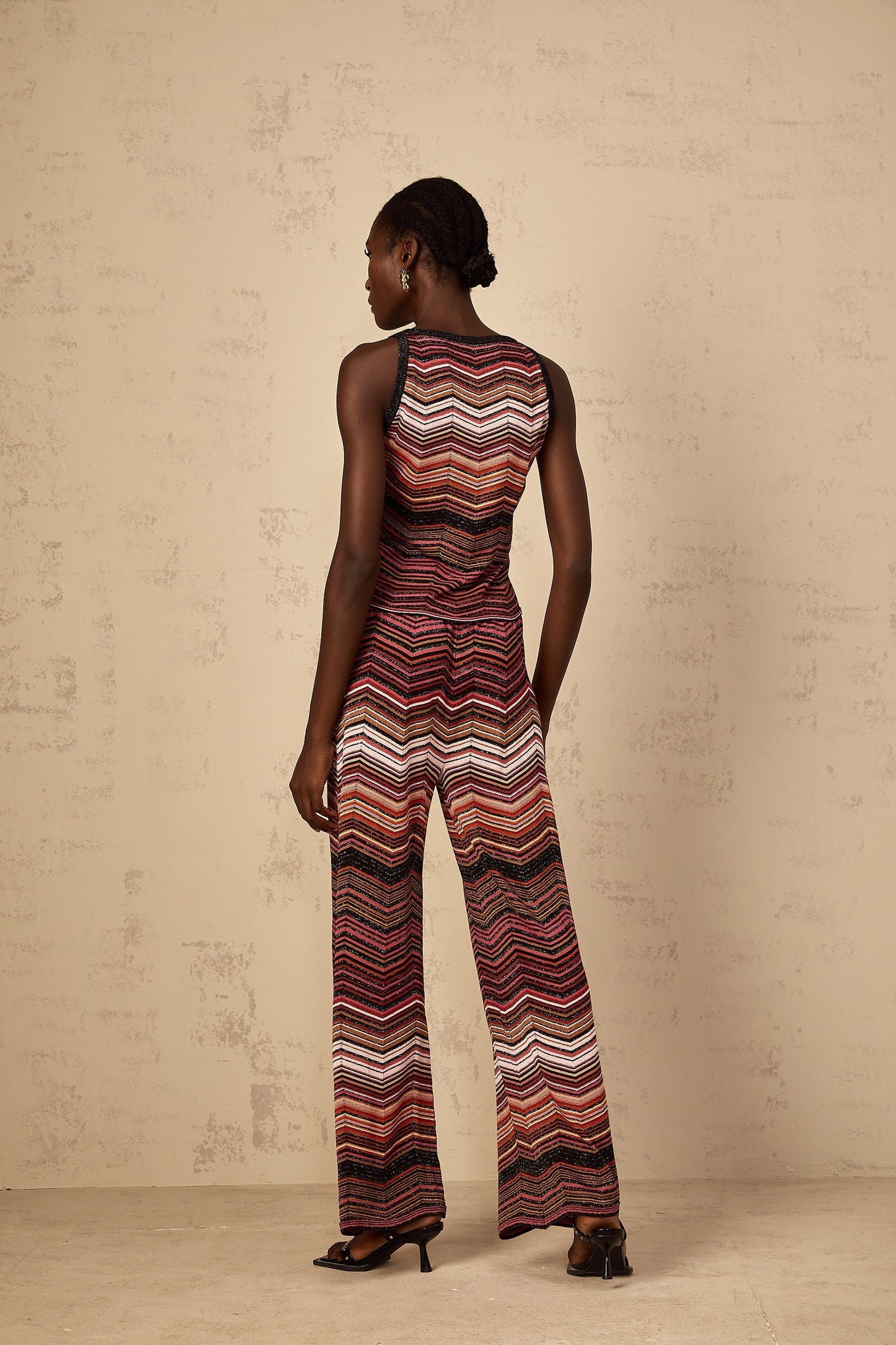 A woman wearing a red and white striped knit matching set from Chloé consisting of a long sleeve top and pants