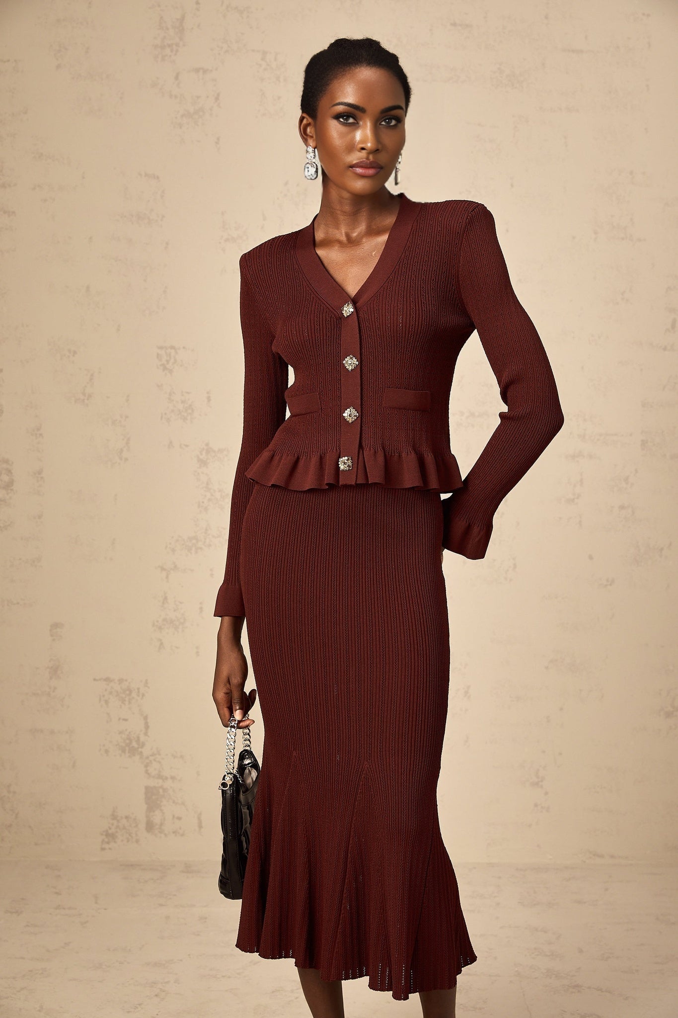 A woman wearing a red knit top with ruffled details paired with a matching skirt forming a coordinated set
